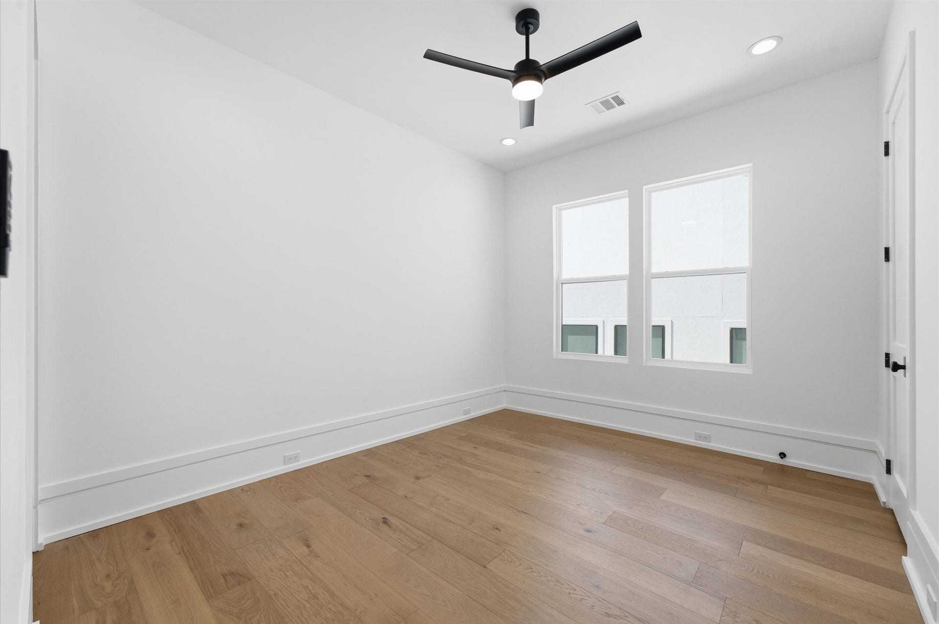 4313 Lula Street, Bellaire, TX 77401 Bright secondary bedroom featuring wood flooring, ceiling fan, and natural light.