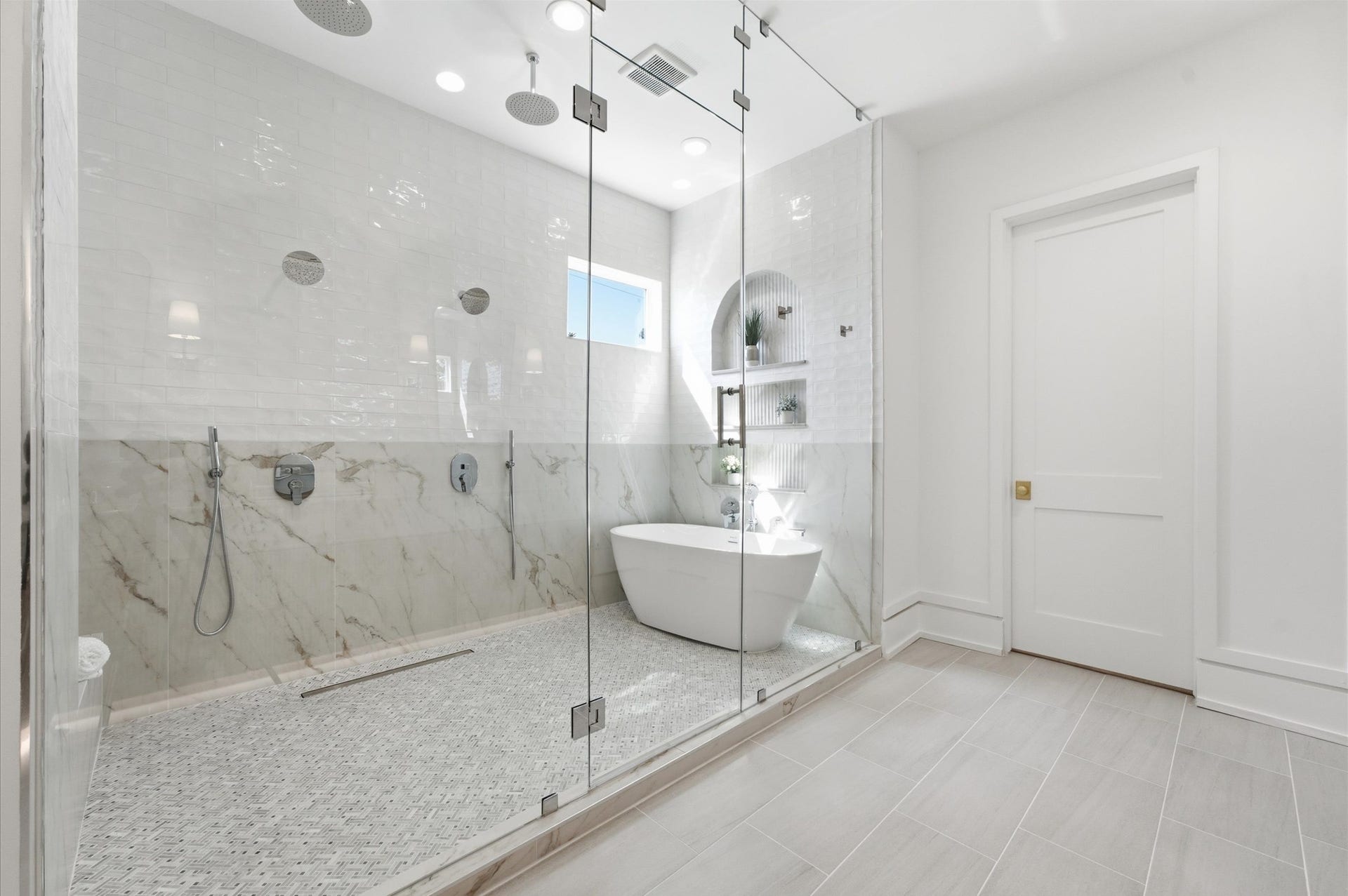 4313 Lula Street, Bellaire, TX 77401 Luxurious bathroom with glass-enclosed shower, freestanding tub, and modern finishes.