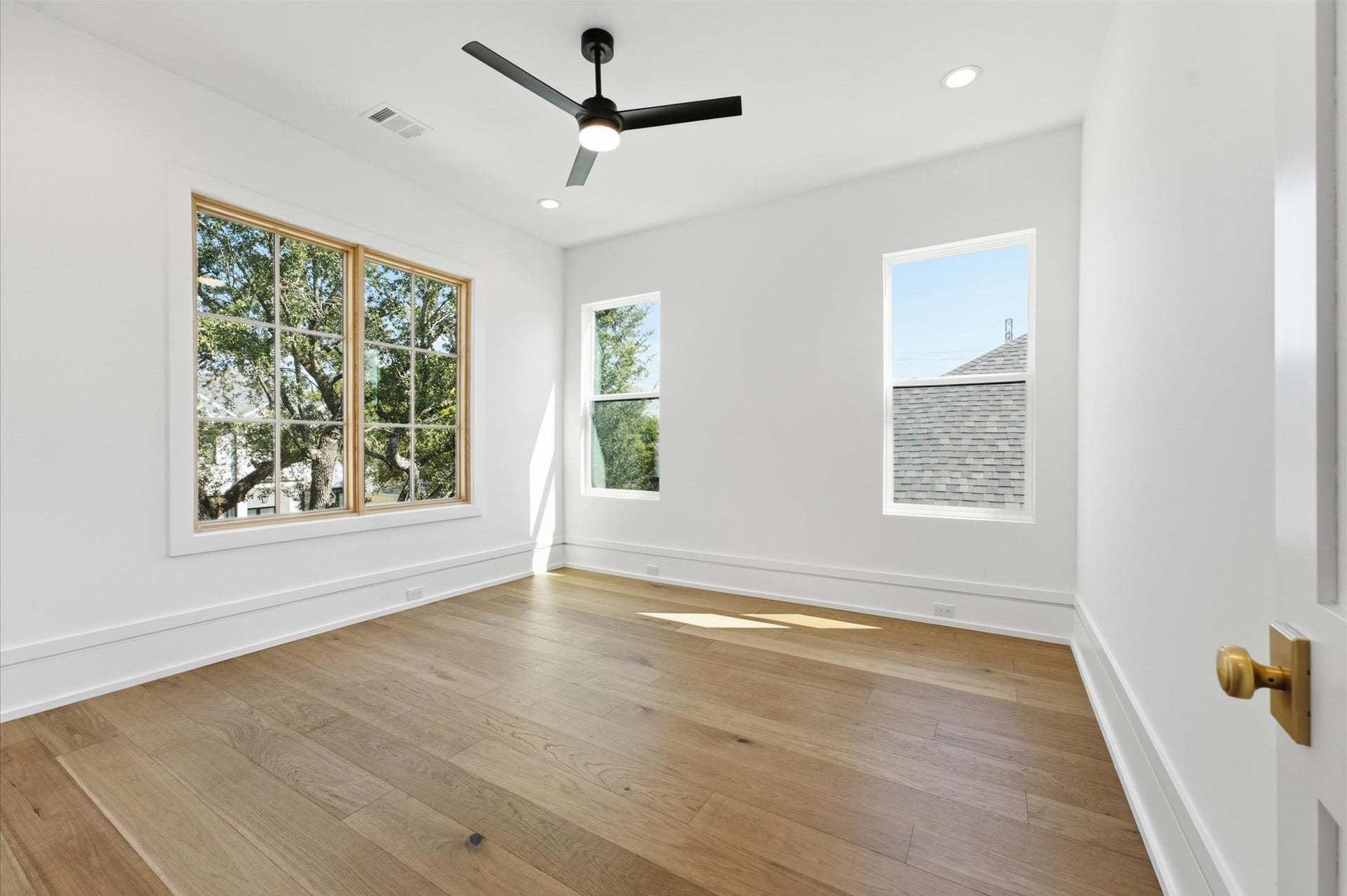 4313 Lula Street, Bellaire, TX 77401 Bright bedroom with wood flooring, ceiling fan, and multiple windows.