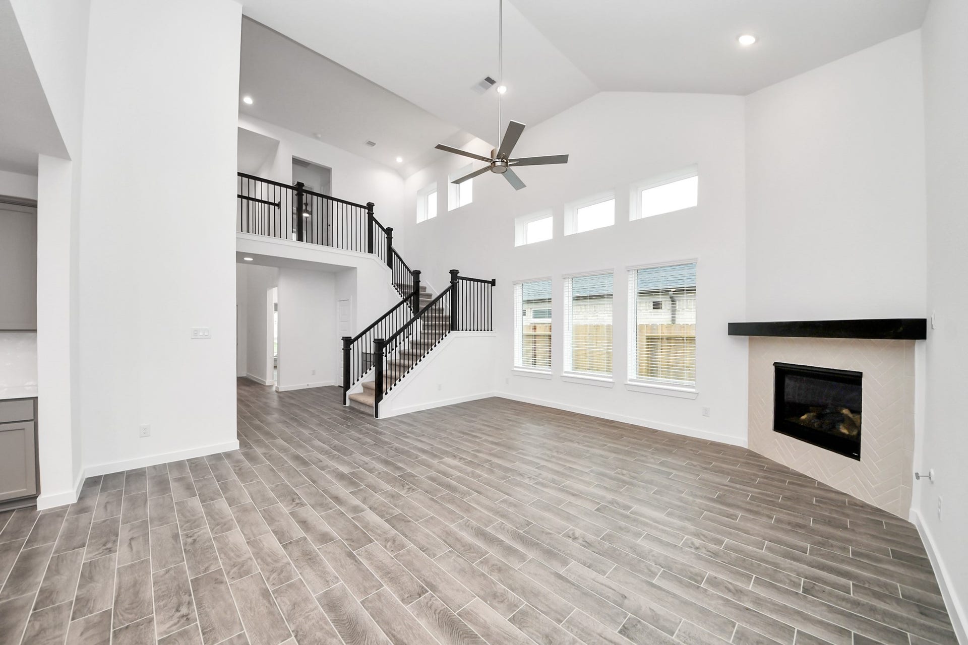 24514 Broad Park Ct, Spring, TX 77373 Relax and unwind in this inviting family room, illuminated by abundant natural light streaming in through tall windows, complemented by high ceilings and stunning flooring. Stay comfortable year-round with the gentle breeze from the ceiling fan, creating the perfect atmosphere for family gatherings.