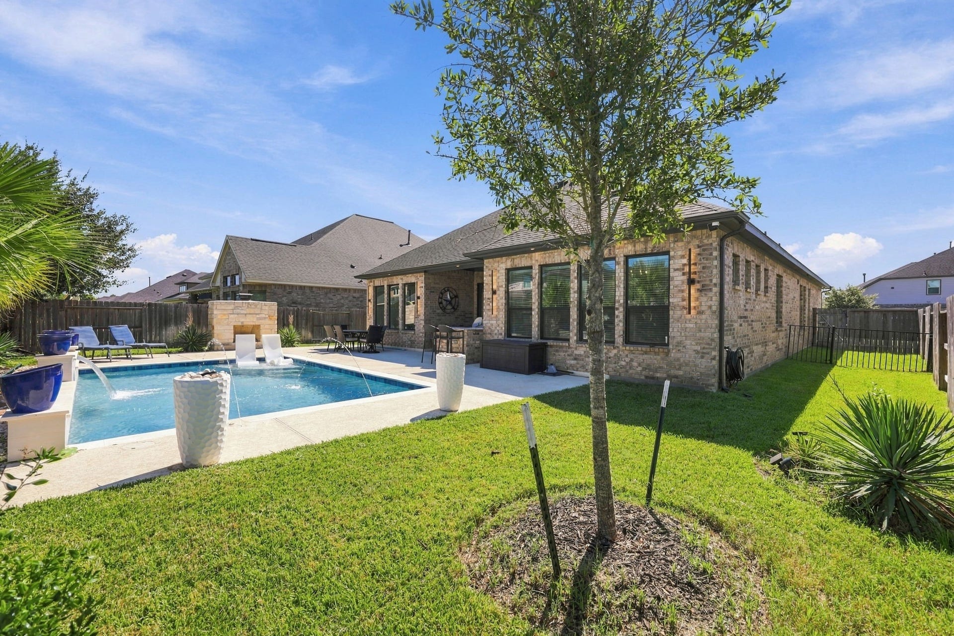 Take in the complete backyard experience: a heated pool, covered patio, outdoor kitchen, and fireplace, all in one beautiful setting that you get to call HOME!