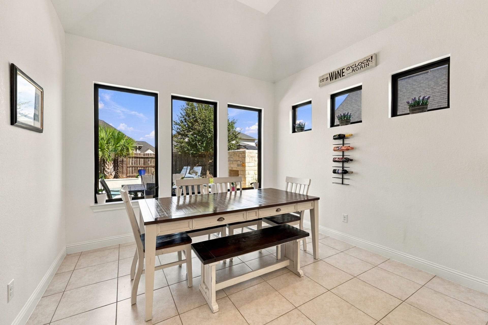 Just beyond the kitchen, the dining area features upgraded lighting and beautiful views of the backyard.