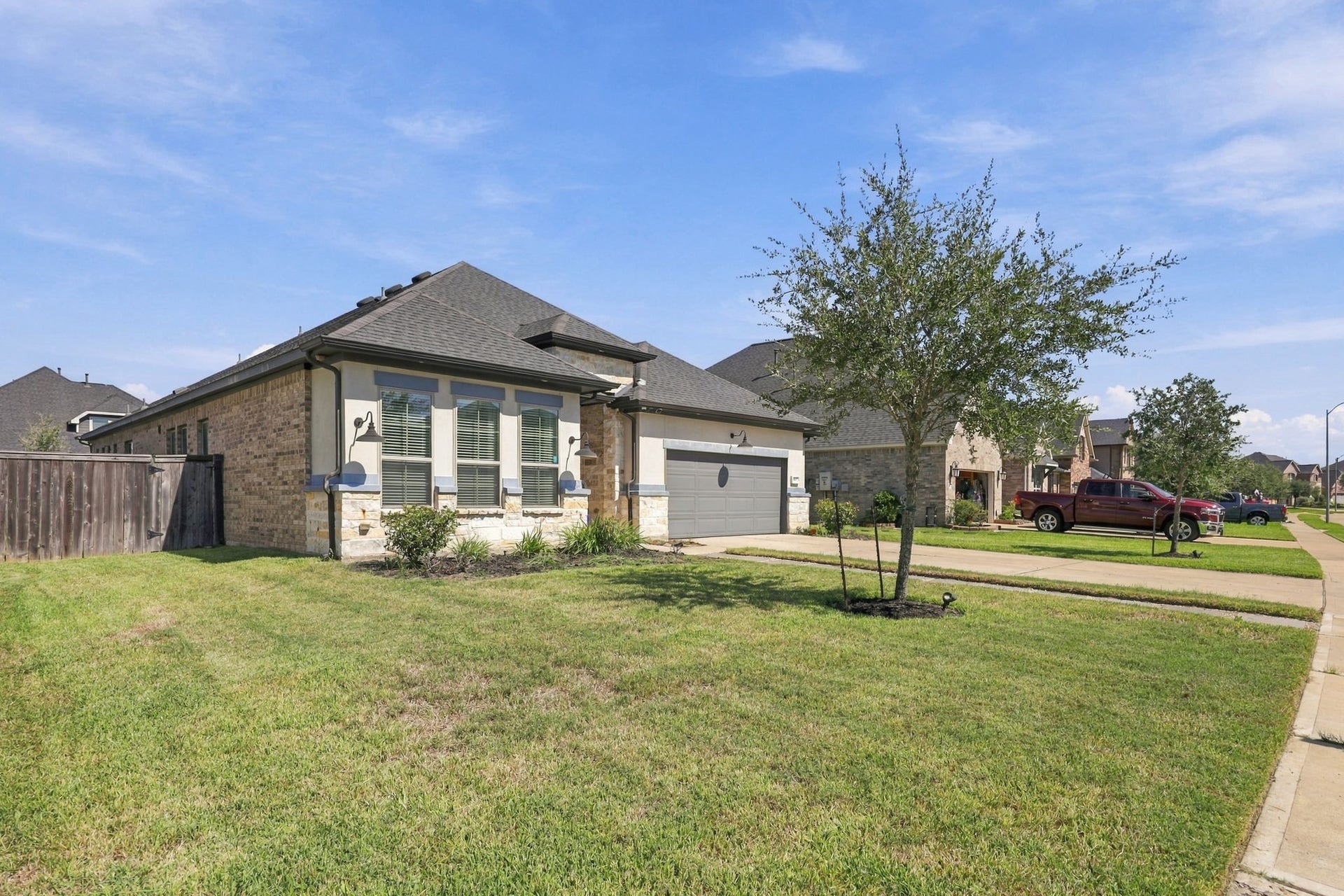 As you approach, notice the attractive brick and stone exterior, spacious driveway, and beautifully maintained landscaping.
