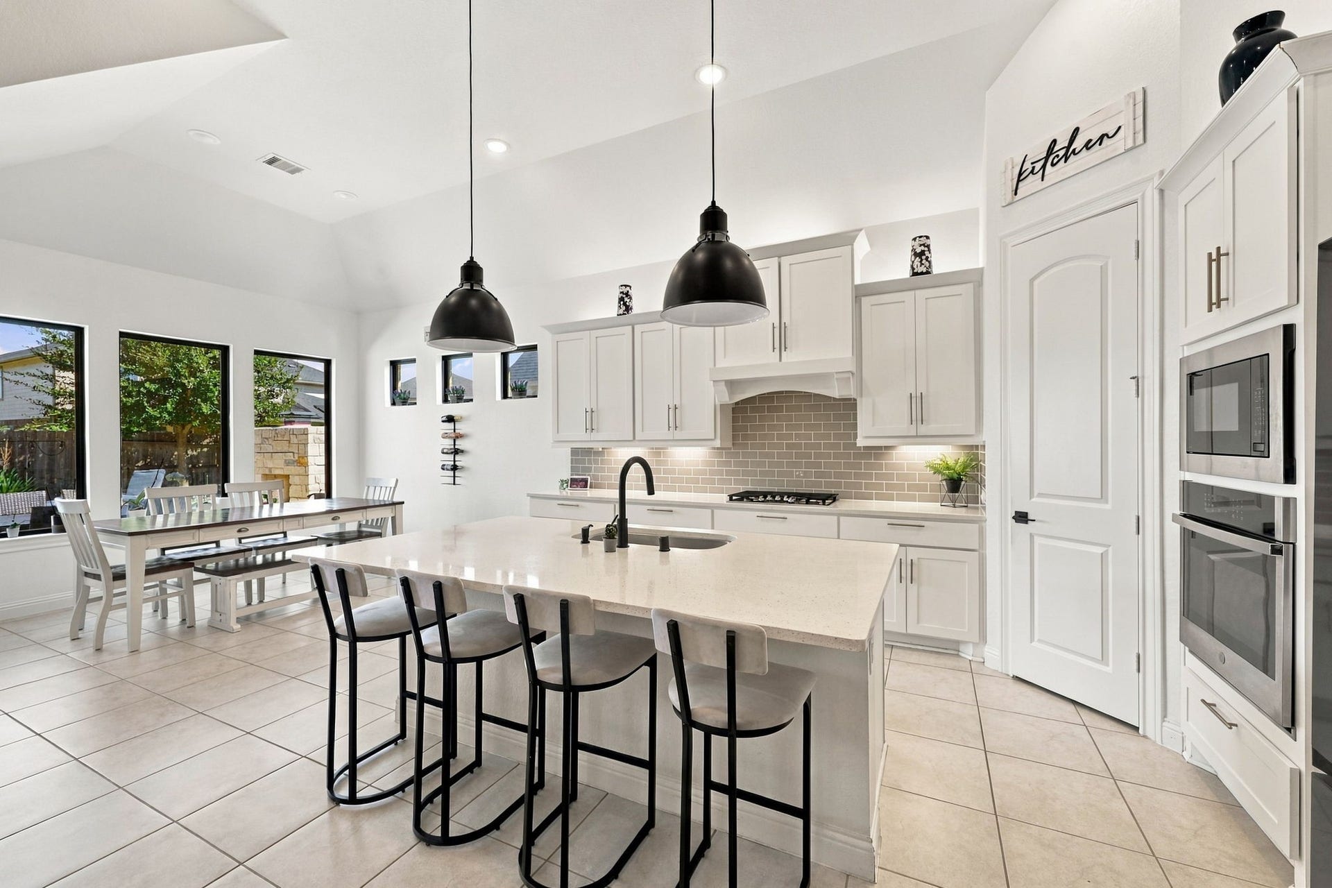 Moving into the kitchen, you'll find a spacious center island, upgraded pendant lighting, and additional cabinetry.