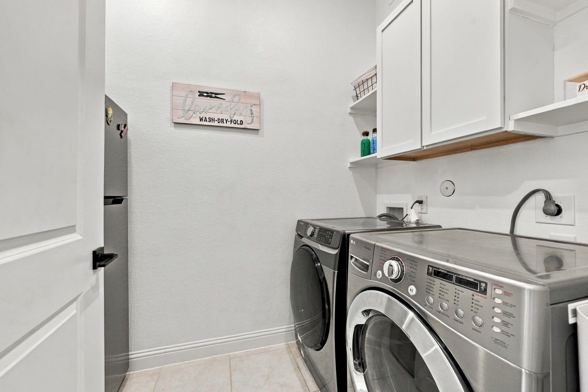 The dedicated laundry room offers cabinetry and practical space to make daily household tasks easier.
