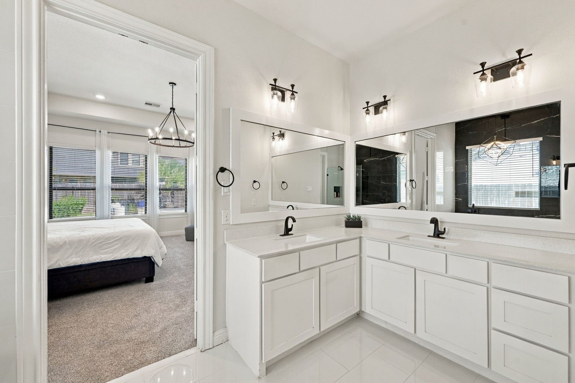 Step into the beautifully upgraded primary bathroom, featuring dual vanities, generous cabinetry space, and elegant finishes.