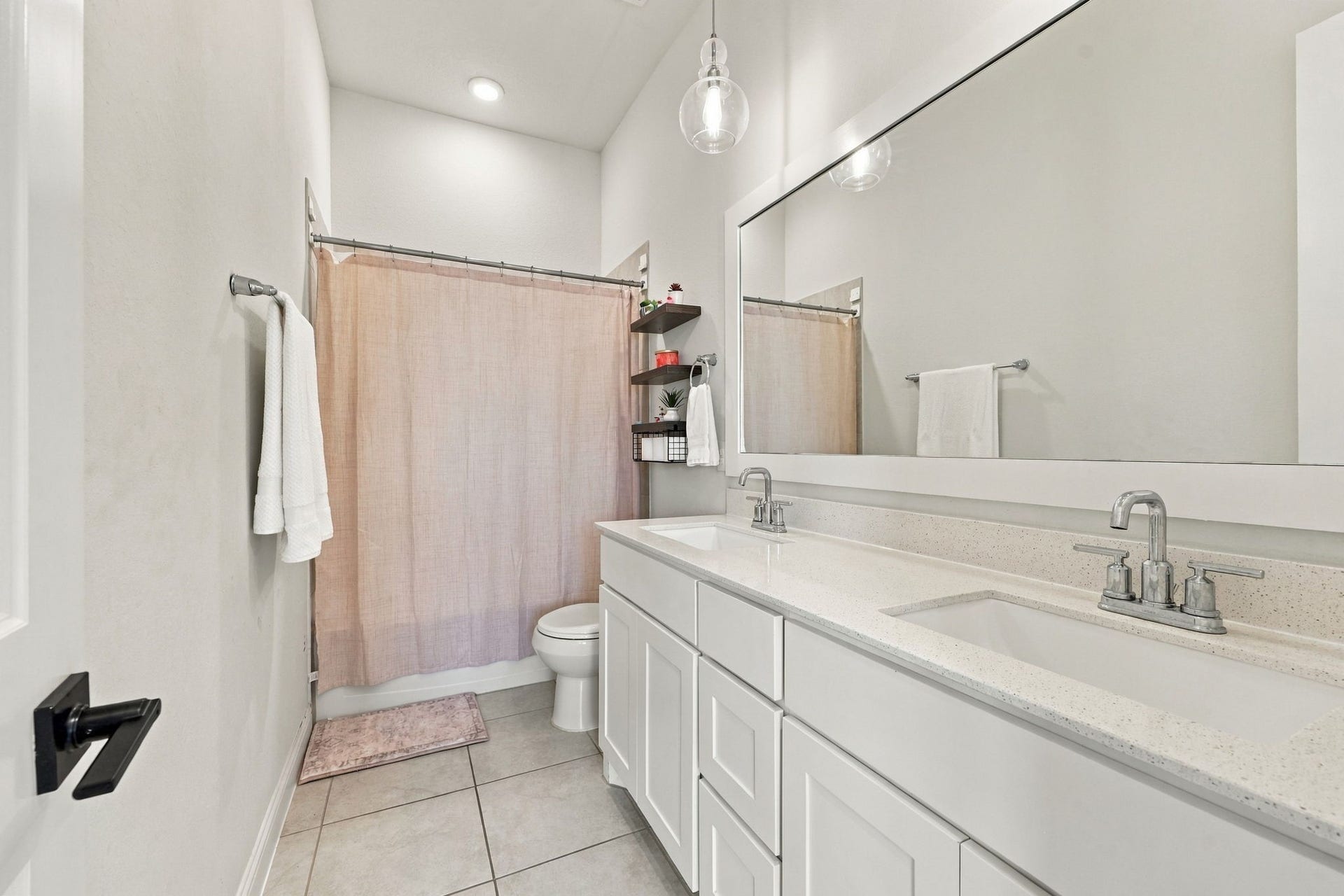 This additional full bathroom features a spacious dual-sink vanity and ample cabinetry for everyday convenience.