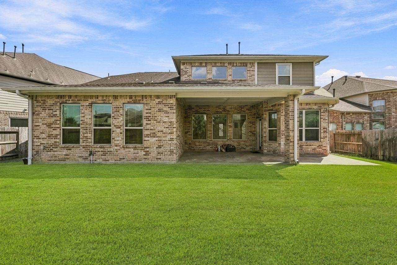 2215 Hermina Radler Drive, Richmond, TX 77469 A sophisticated rear elevation showcasing the home's architectural poise and seamless connection to the outdoor living space.