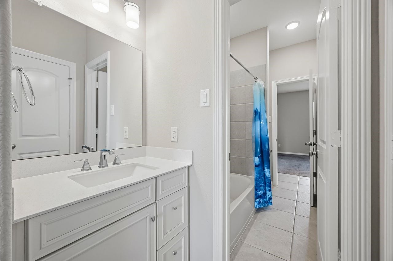 2215 Hermina Radler Drive, Richmond, TX 77469 A detailed view of the dedicated vanity within the shared ensuite, offering a seamless and sophisticated transition between the two sleeping quarters.