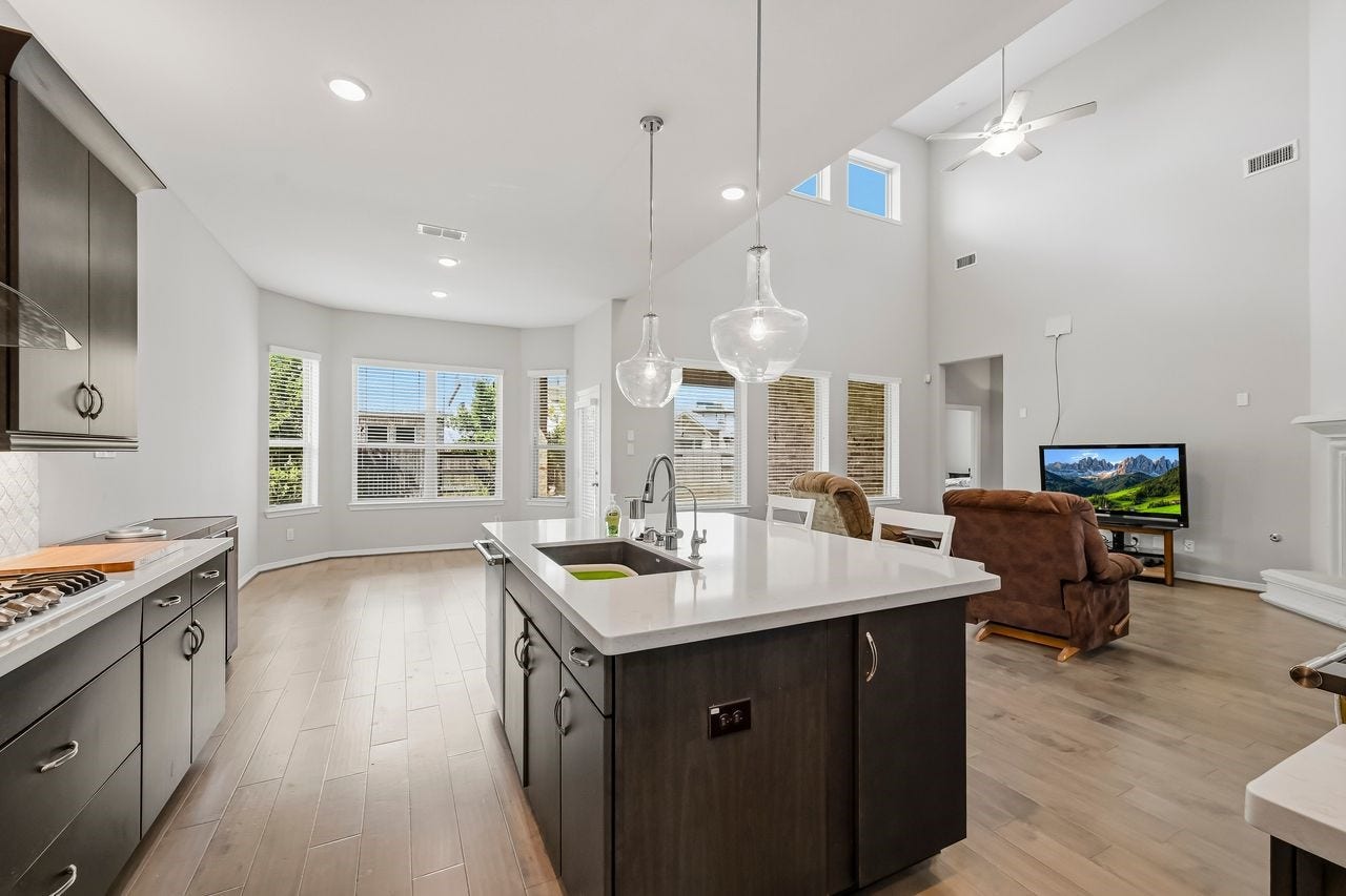 2215 Hermina Radler Drive, Richmond, TX 77469 Expansive windows flood the space with natural light, seamlessly connecting the breakfast bay to the living area under the glow of elegant recessed lighting.