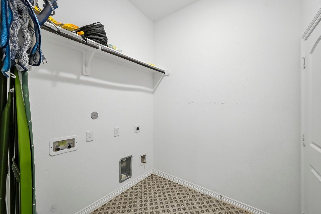2215 Hermina Radler Drive, Richmond, TX 77469 Thoughtfully designed utility space featuring custom built-in shelving and integrated hanging rails for seamless organization. This versatile area is fully equipped to accommodate either a gas or electric dryer.