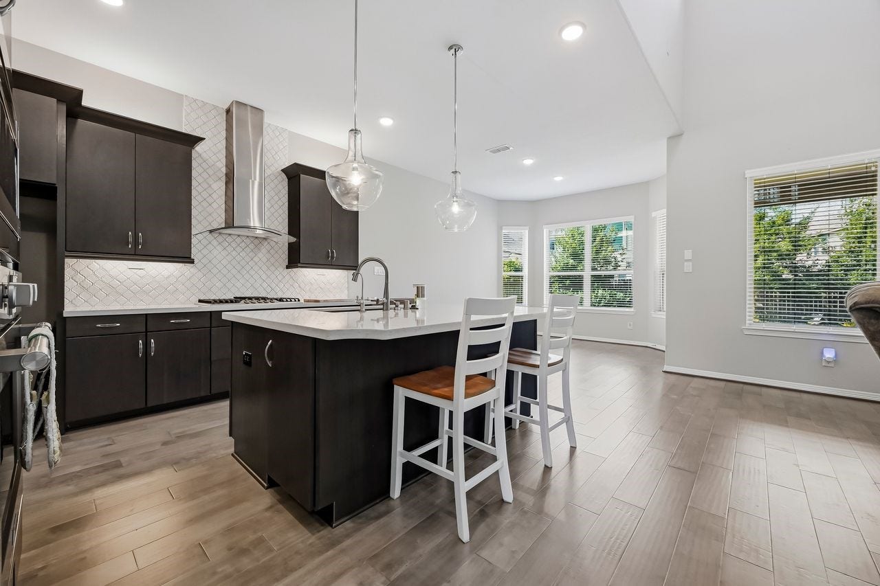 2215 Hermina Radler Drive, Richmond, TX 77469 From the base of the stairs, the view opens to a sophisticated kitchen and breakfast bay. The seamless blend of contemporary finishes and abundant natural light creates a refined setting for hosting and gathering.