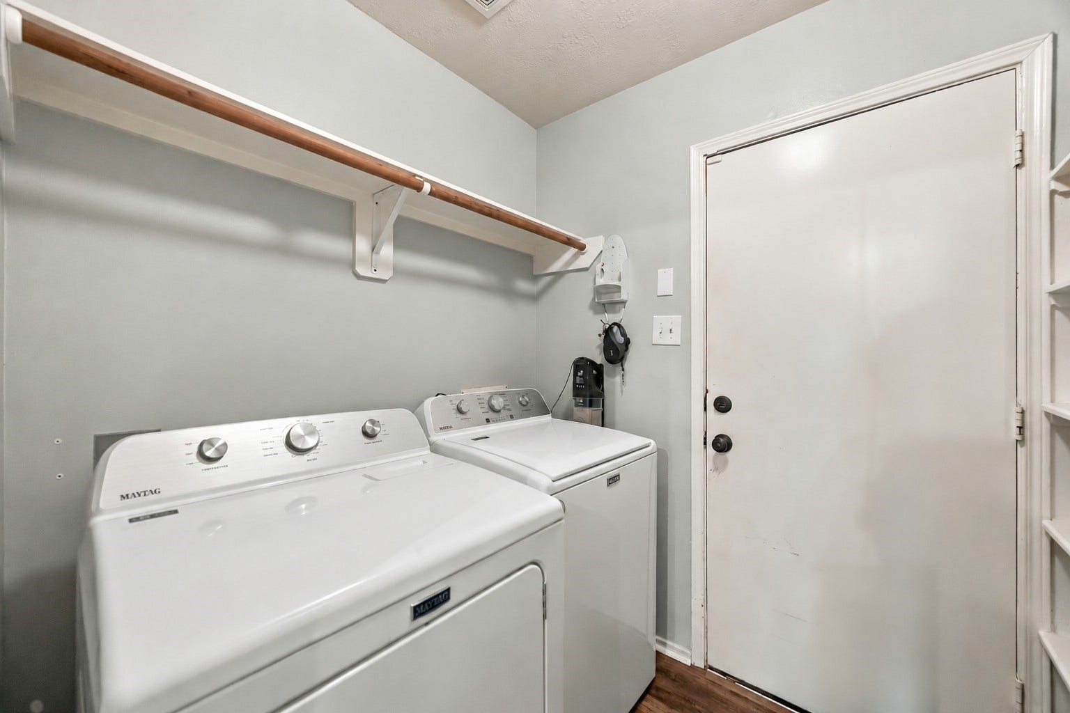 Dedicated interior laundry room provides full-size washer and dryer space with convenient overhead shelving.