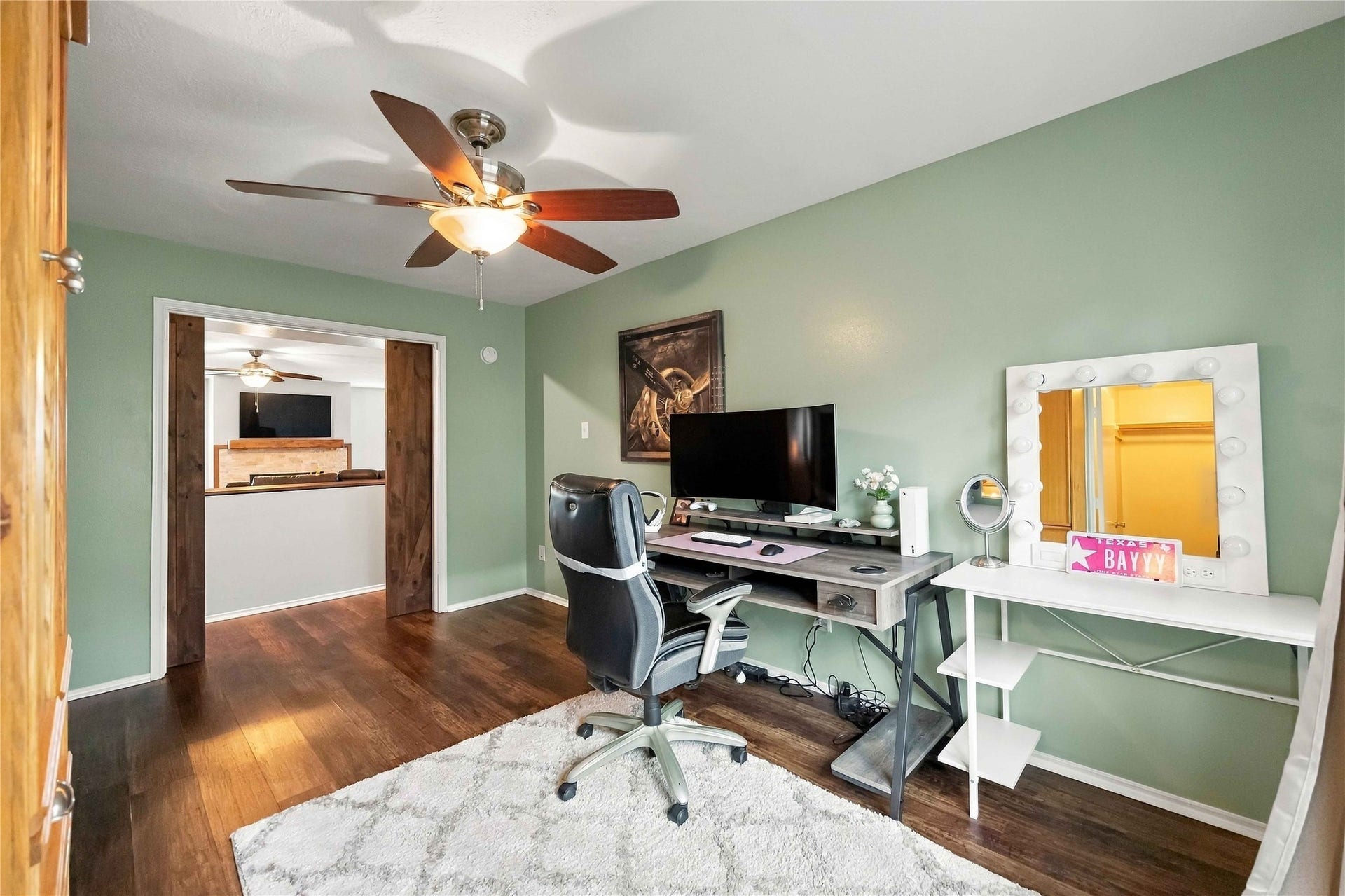 Alternate view highlights the spacious secondary bedroom and distinctive sliding barn-door entry connecting to the main living area.