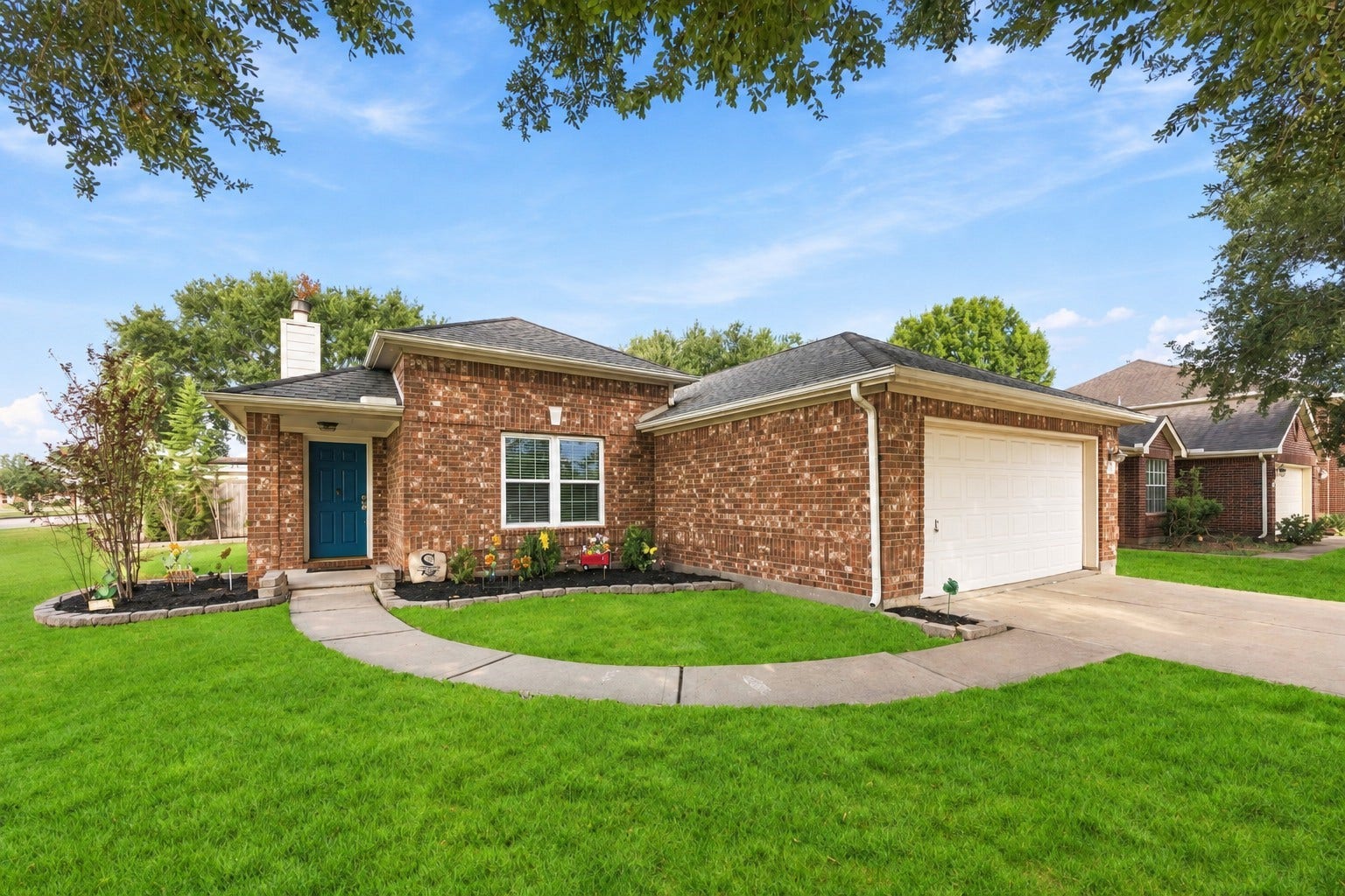 Inviting front elevation featuring classic brickwork, established landscaping, and a covered entry.