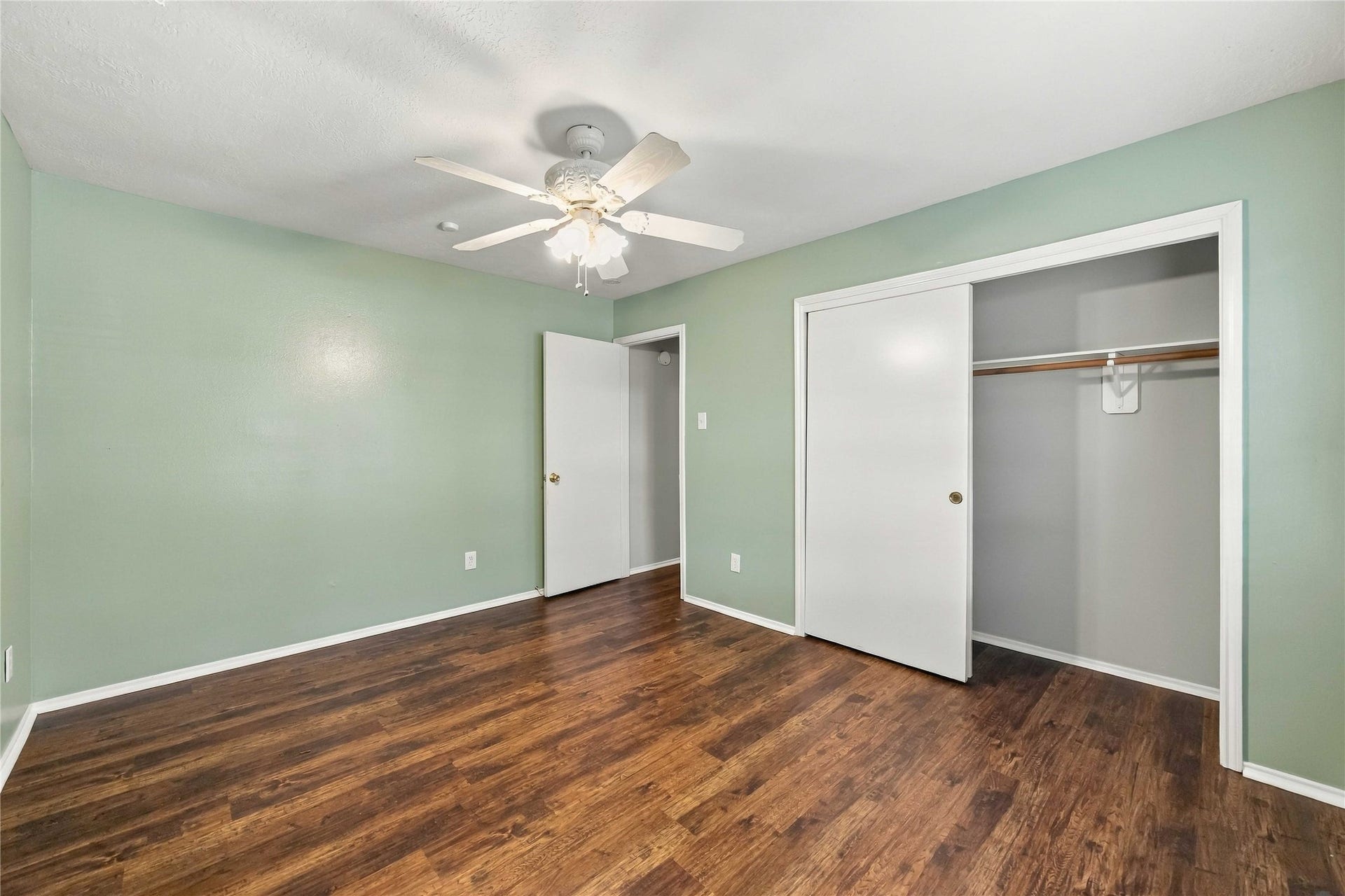 Secondary bedroom includes a wide closet with sliding doors and plenty of room for flexible furniture placement.