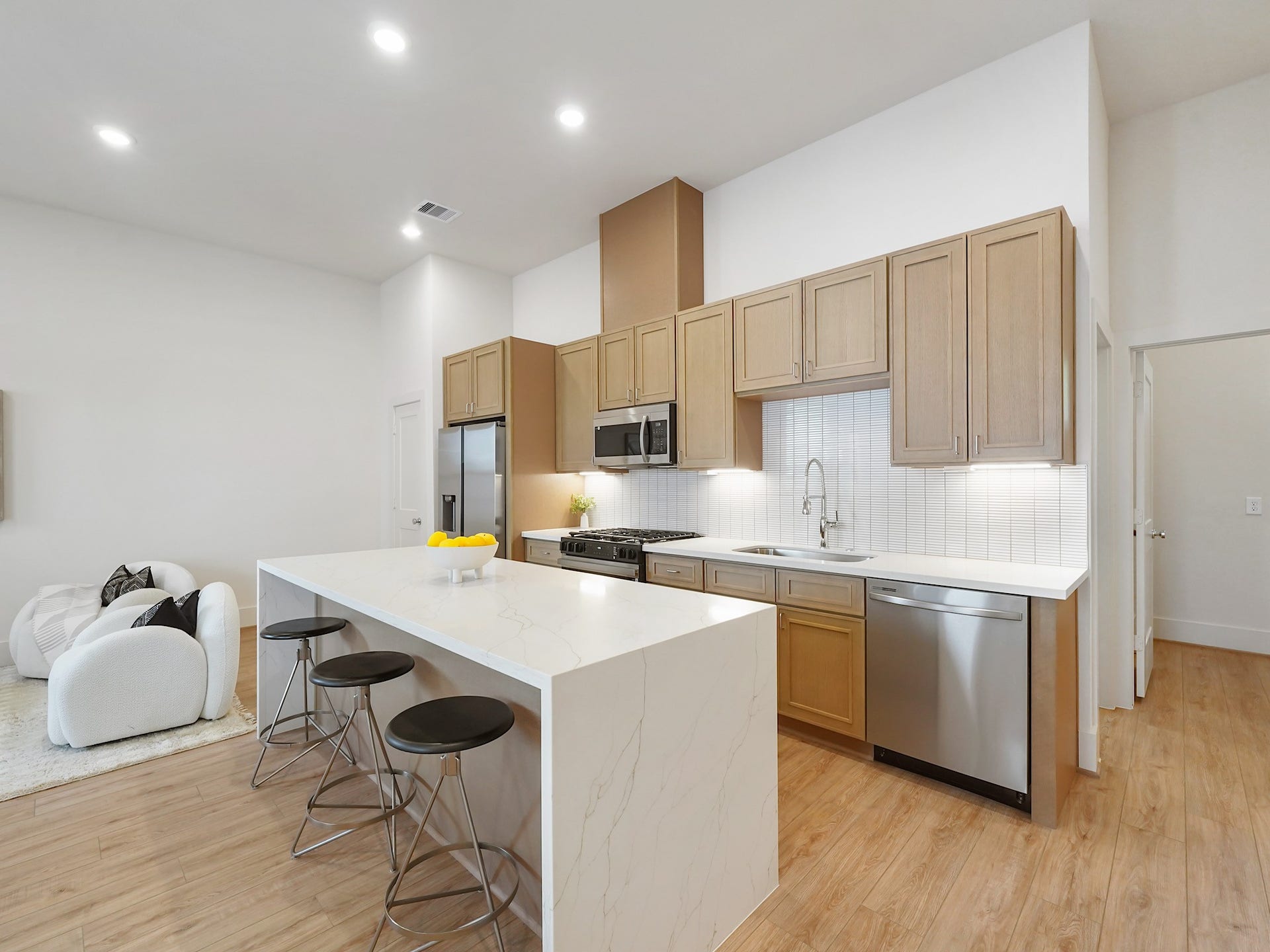 This modern kitchen features sleek stainless steel appliances and a spacious breakfast bar, creating an ideal setting for entertaining guests.
