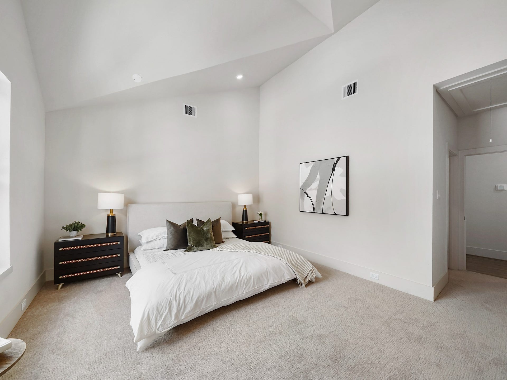 This primary suite offers a spacious retreat with high ceilings and abundant natural light, creating an airy and inviting atmosphere.