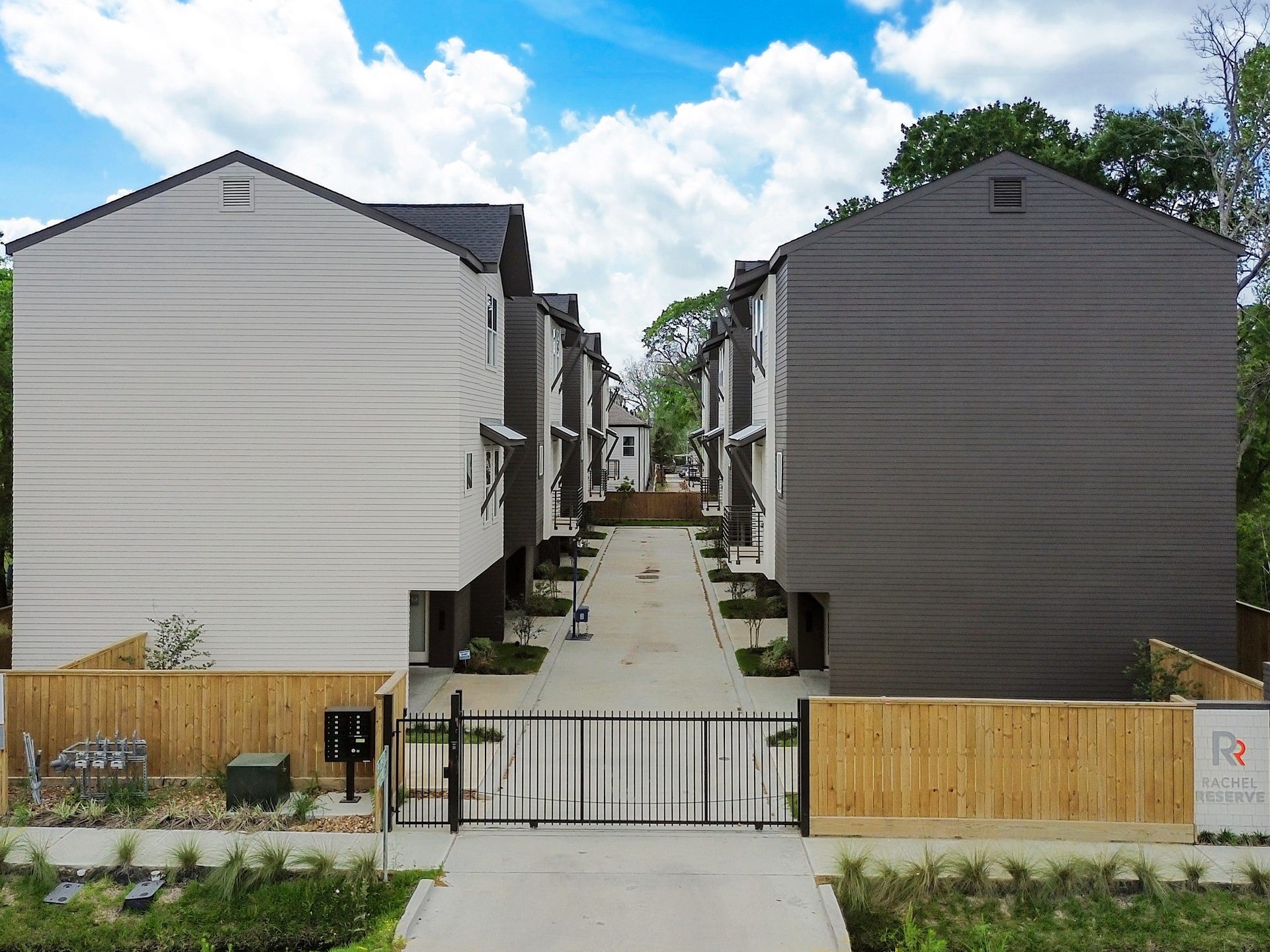 Discover a modern, gated community offering sleek, contemporary townhomes nestled amidst lush greenery, perfect for those seeking style and security.