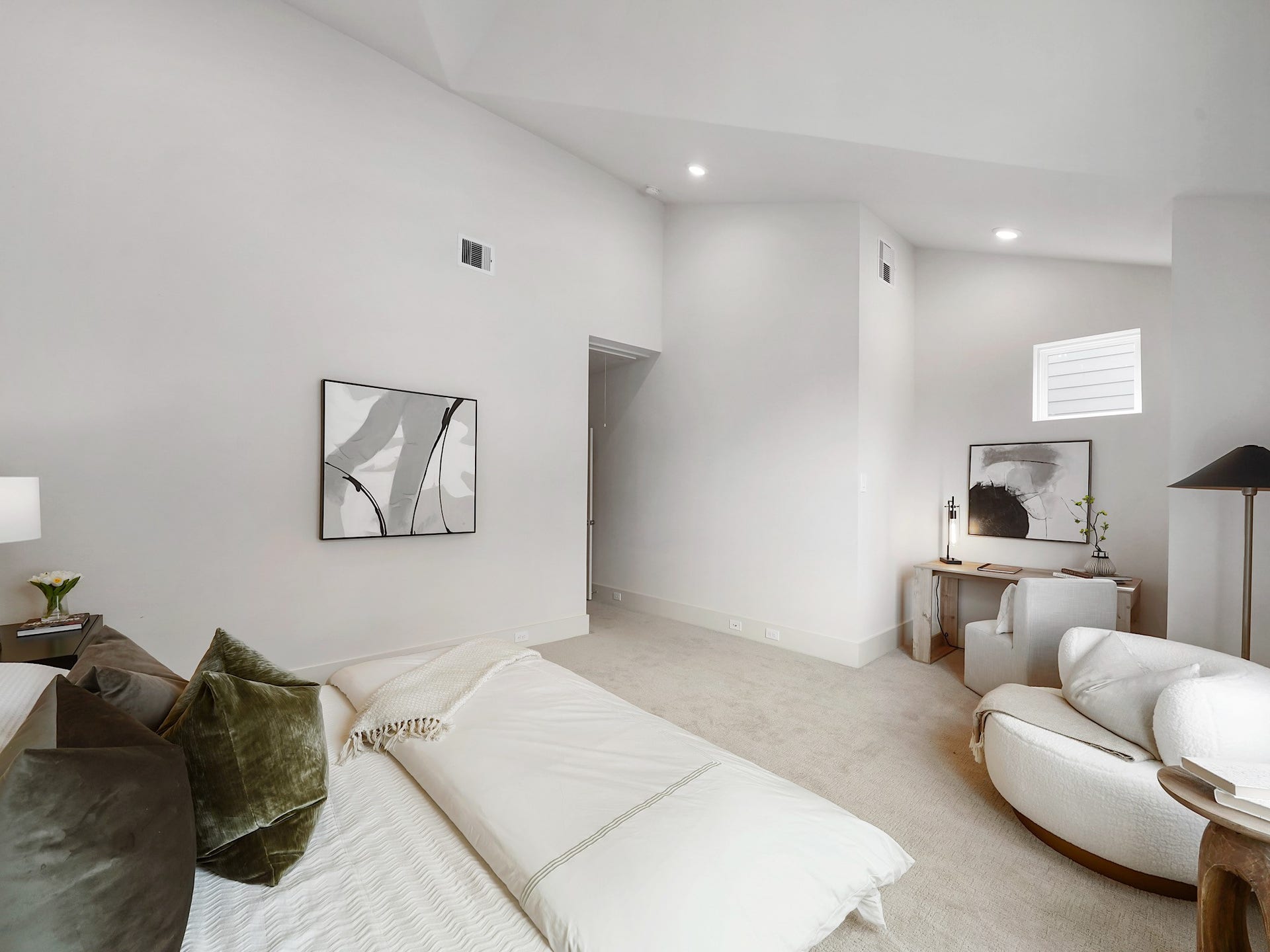 This spacious primary room offers a serene retreat with ample space for relaxation and personalized touches.