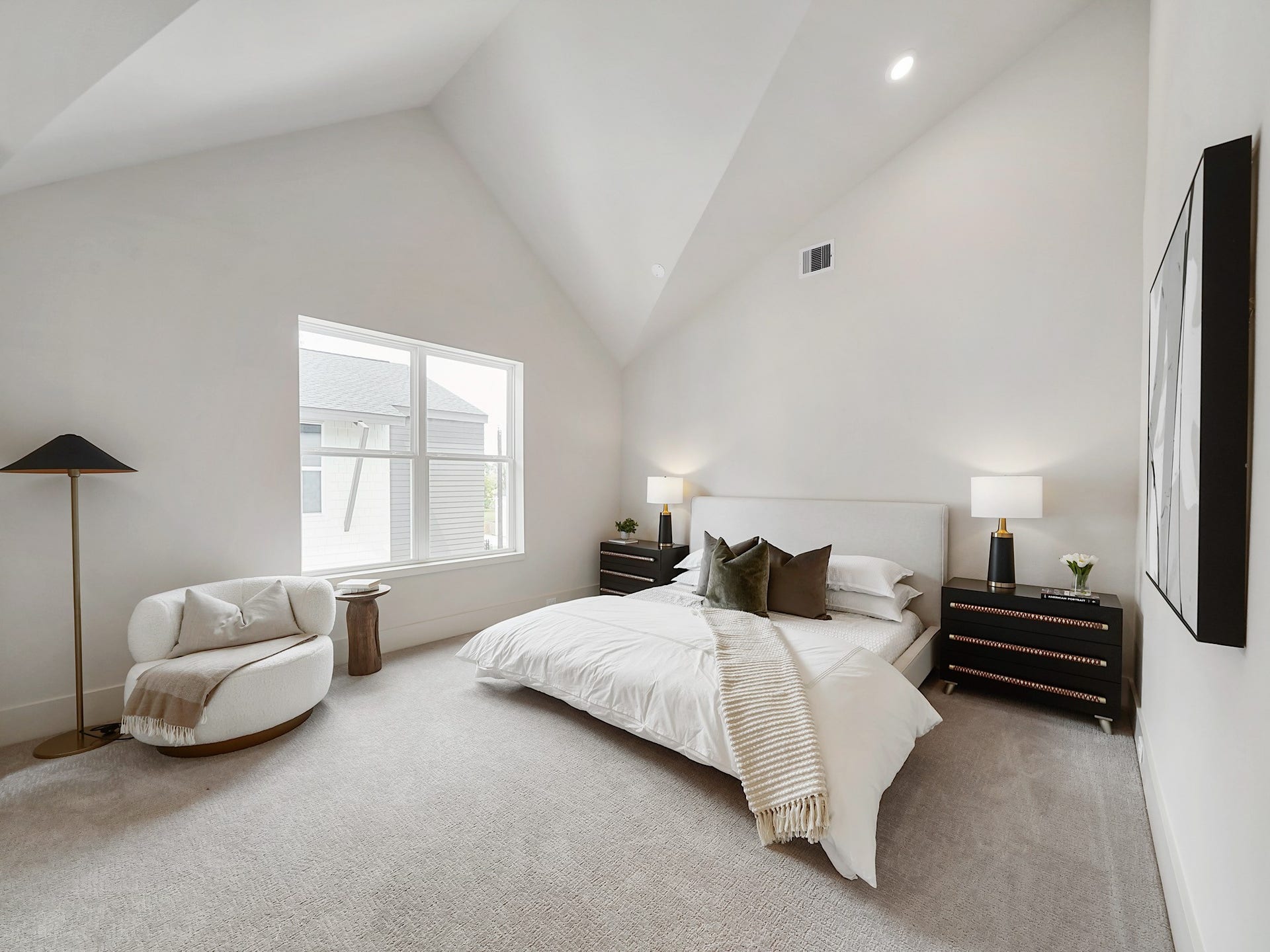 Experience luxury in this bright, spacious bedroom with soaring ceilings and a large window that bathes the room in natural light.