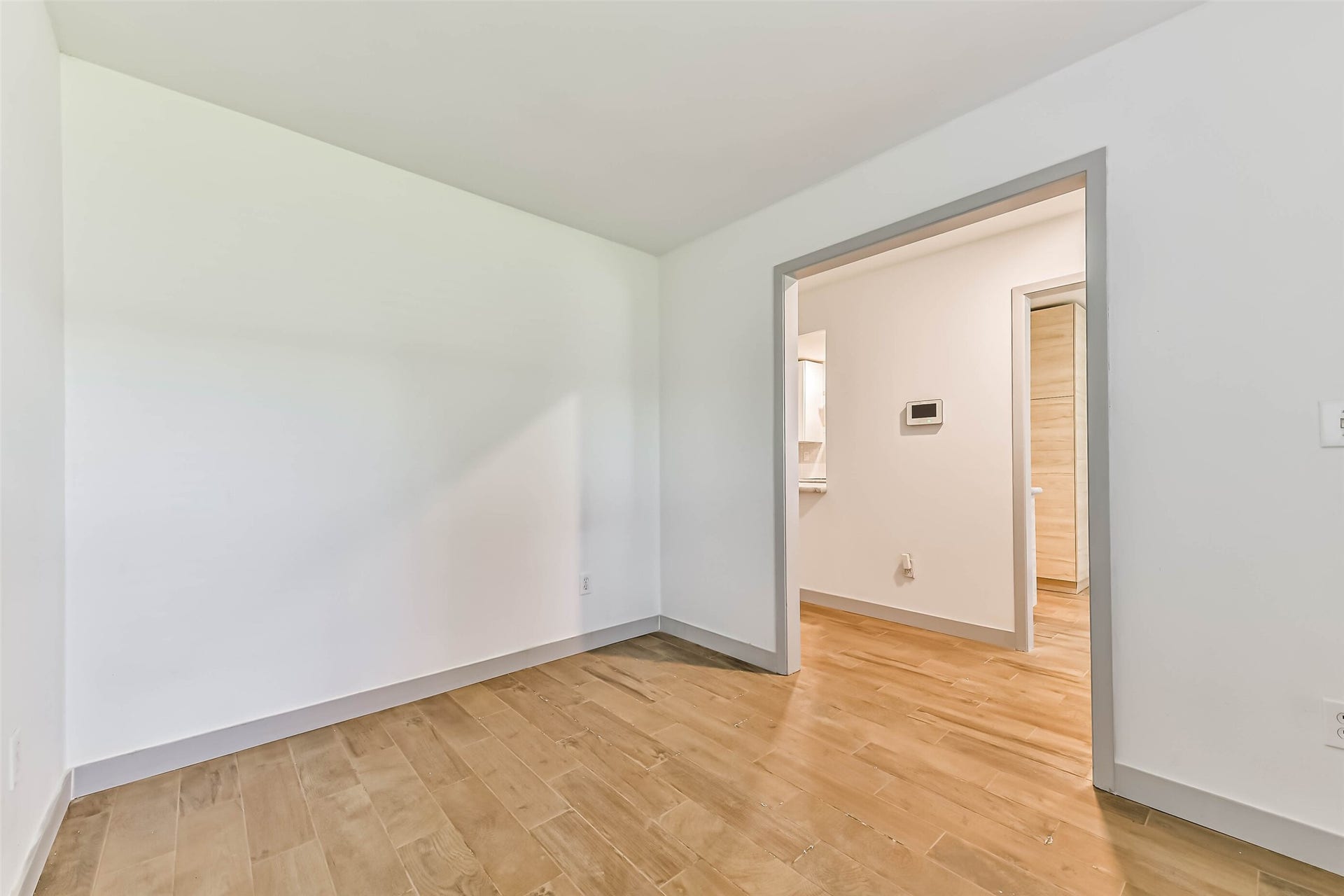 The room features an open doorway leading to another space, offering a clean, modern feel and potential for personalization.