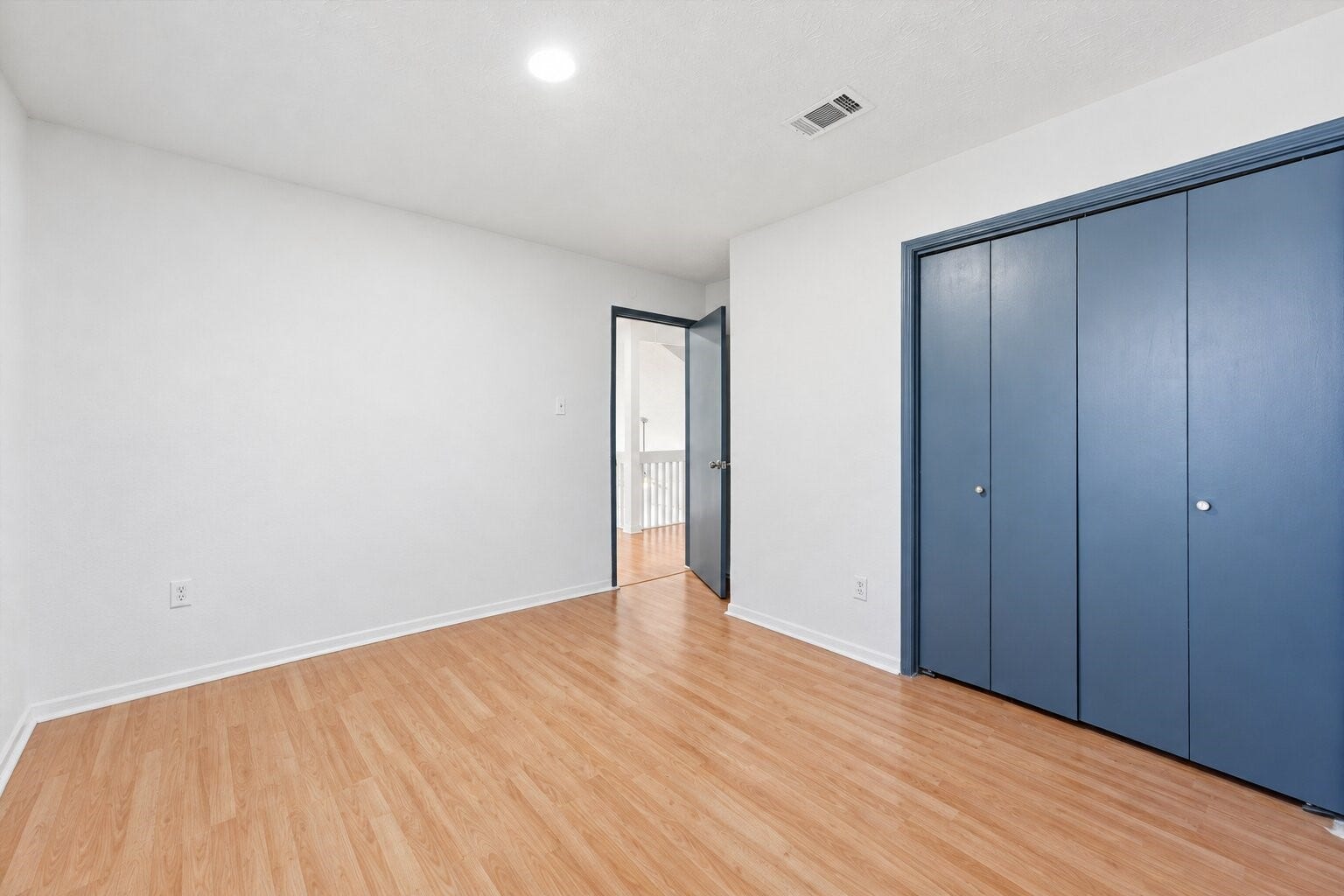 12719 Hollandale Drive, Houston, TX 77082 Secondary bedroom includes a wide double-door closet, wood-look flooring, and a doorway leading toward the hallway.