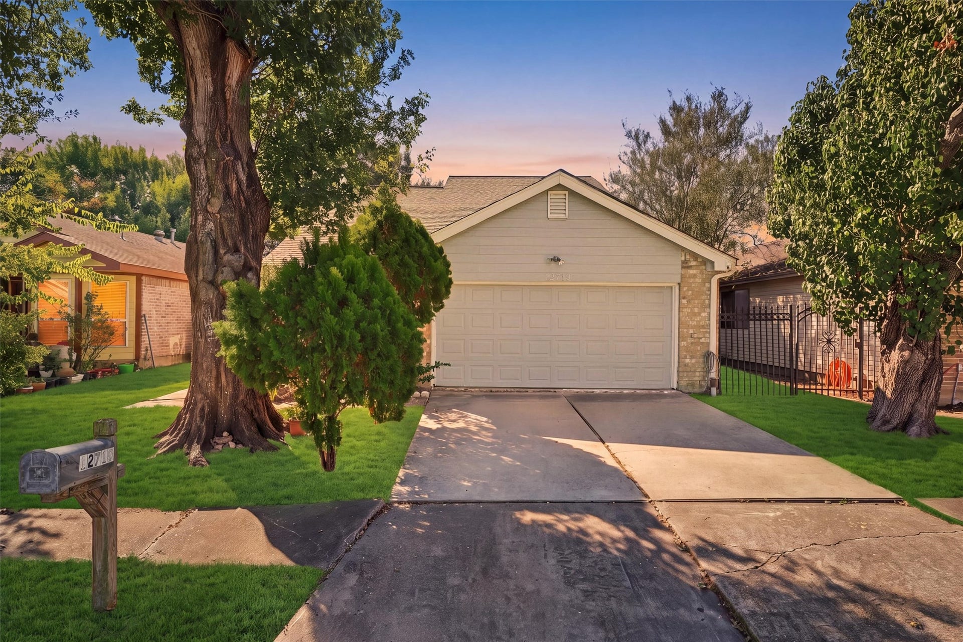 12719 Hollandale Drive, Houston, TX 77082 Mature trees frame the home's inviting exterior, complemented by a green front lawn and a paved driveway.