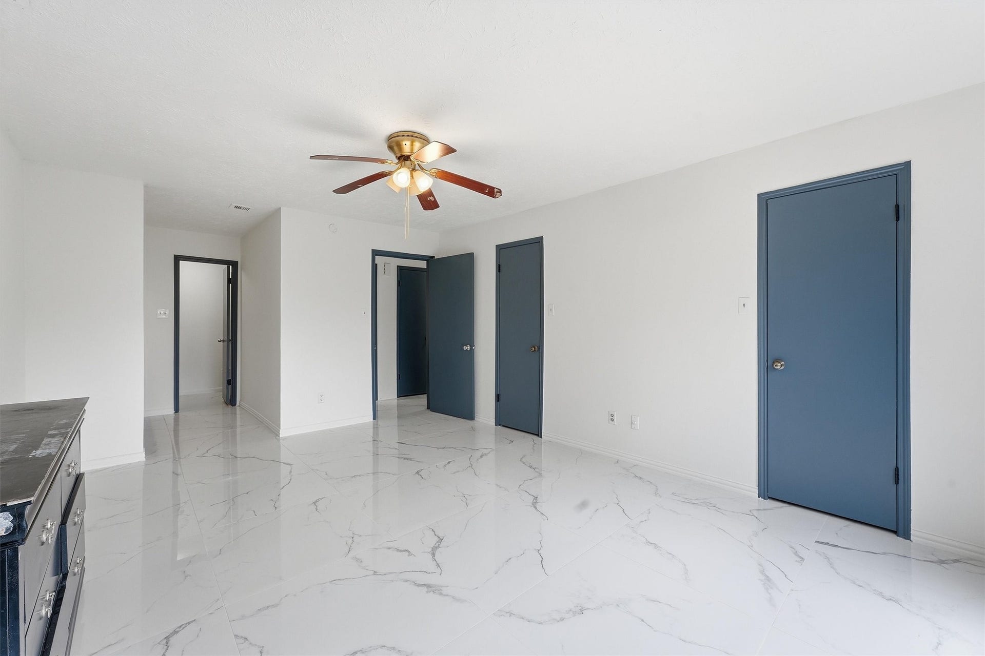 12719 Hollandale Drive, Houston, TX 77082 Spacious primary bedroom opens to the backyard through sliding glass doors, complemented by marble-look tile flooring.