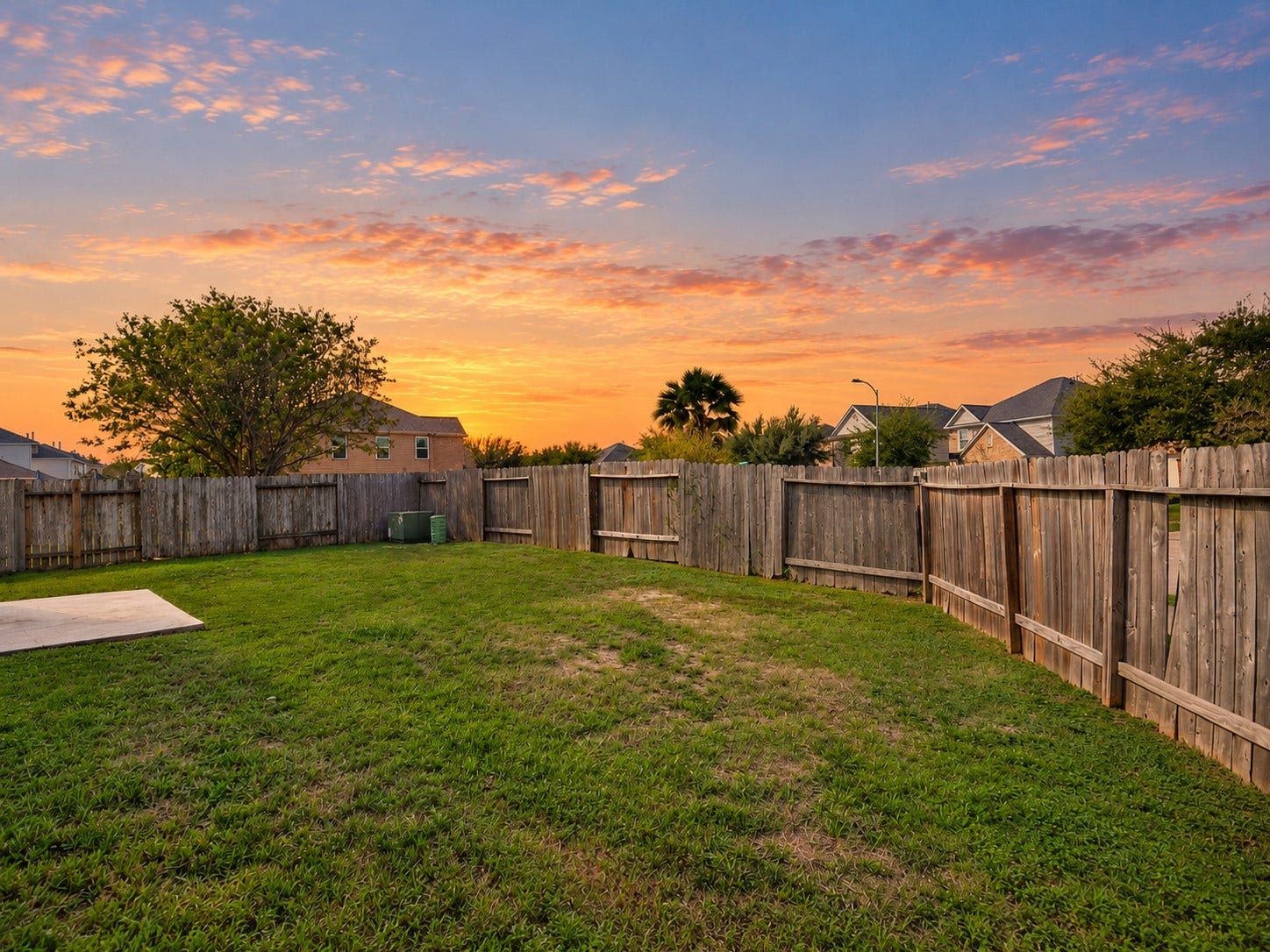 5031 Grove Square Court, Katy, TX 77449 Additional backyard view highlighting the generous lawn, privacy fencing and beautiful evening sky.