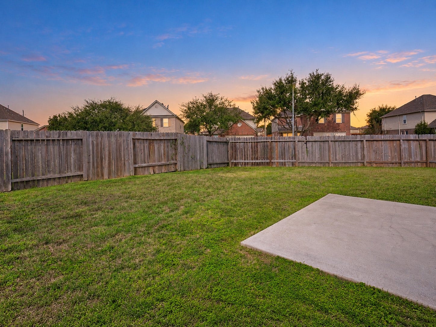 5031 Grove Square Court, Katy, TX 77449 Spacious fenced backyard with an open lawn and concrete patio, offering flexibility for outdoor entertaining and recreation.