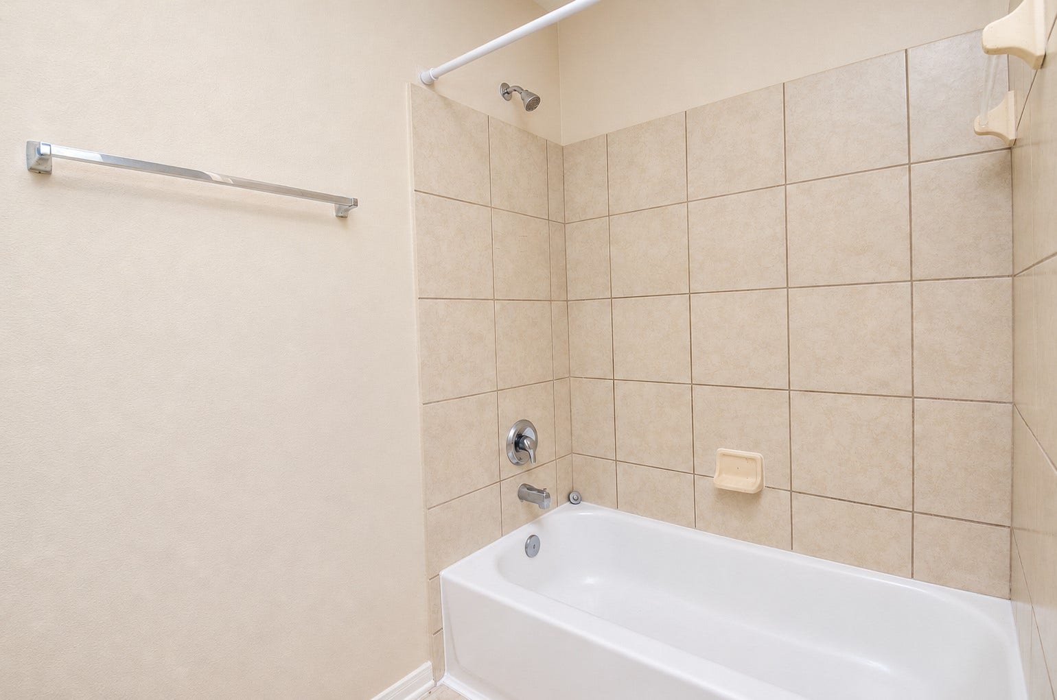 5031 Grove Square Court, Katy, TX 77449 Upstairs bathroom with a tub/shower combination, tiled surround and convenient built-in soap dish.