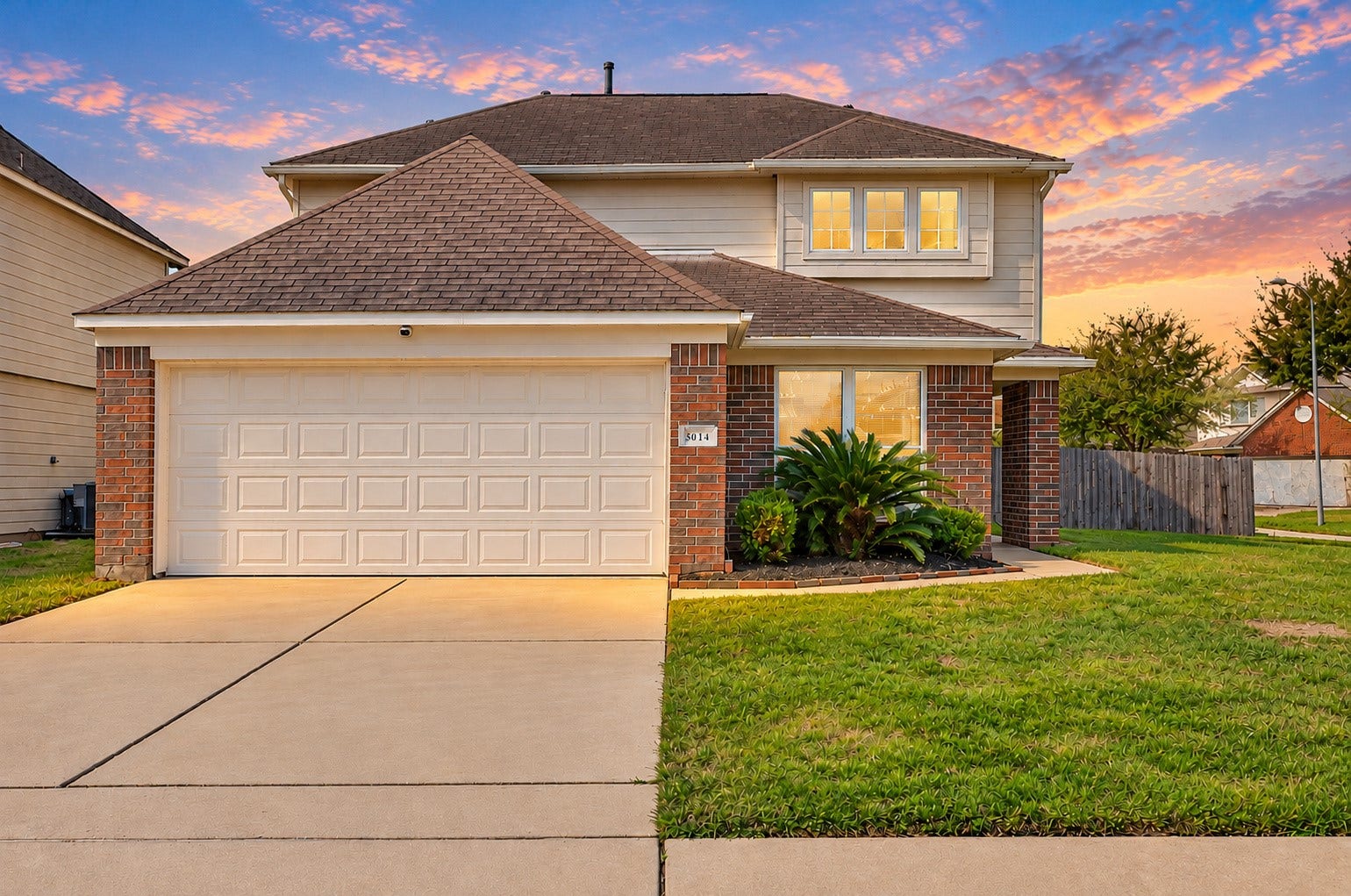 5031 Grove Square Court, Katy, TX 77449 Welcoming front elevation featuring attractive brick and stone accents, an attached 2-car garage and a wide driveway.