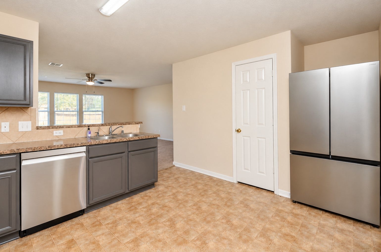 5031 Grove Square Court, Katy, TX 77449 Additional kitchen view showcasing the stainless steel refrigerator, dishwasher, ample cabinetry and open connection to the family room.