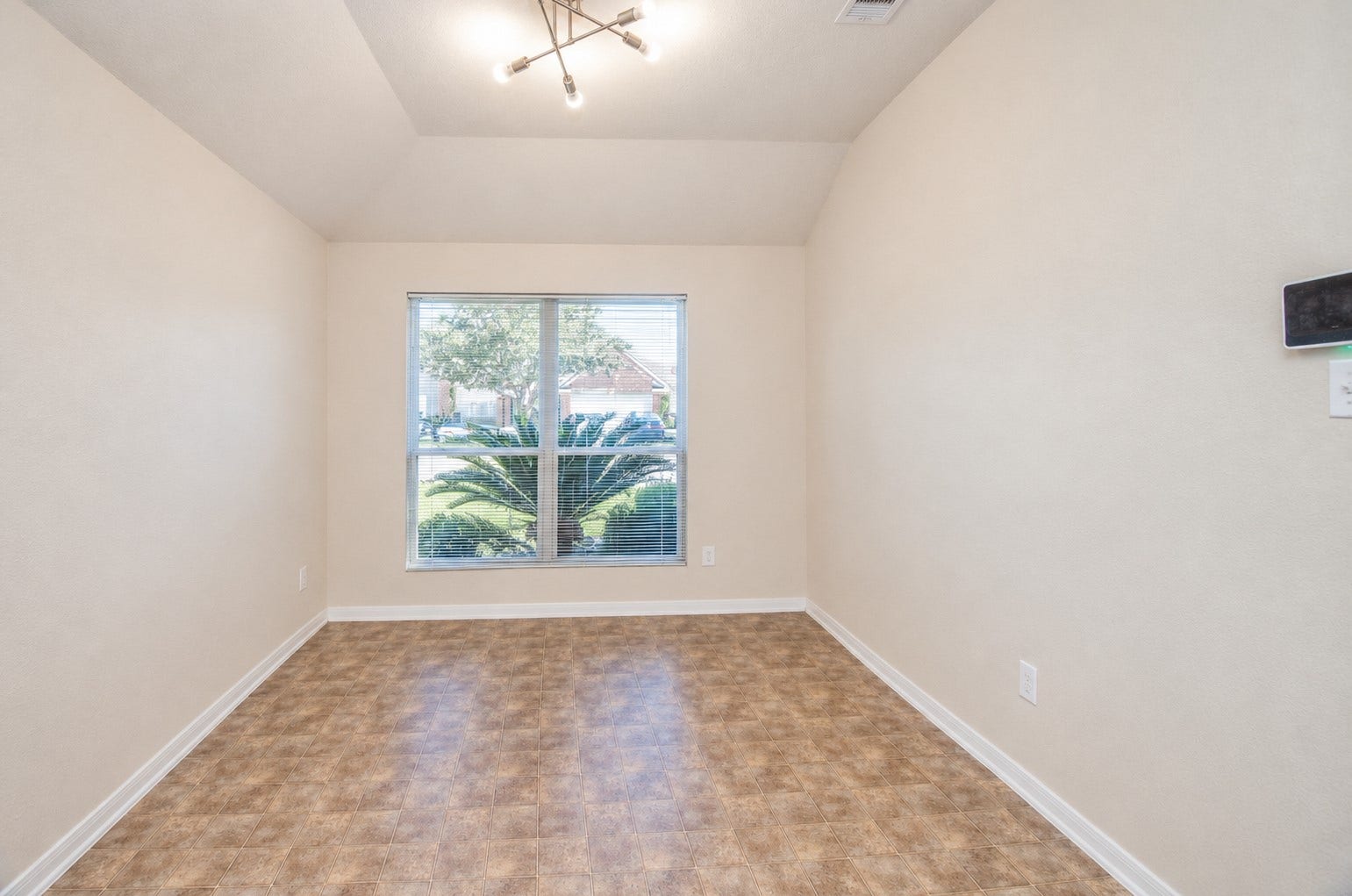 5031 Grove Square Court, Katy, TX 77449 Formal dining room with a vaulted ceiling, decorative light fixture and large window overlooking the front landscaping.