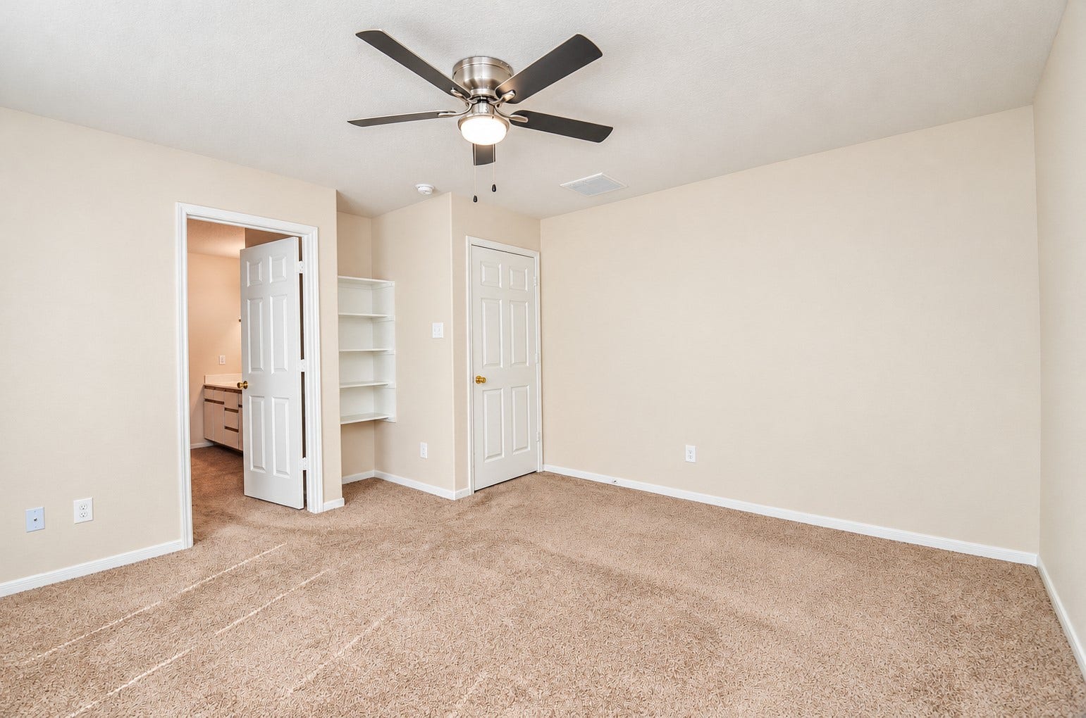 5031 Grove Square Court, Katy, TX 77449 Additional view of the first-floor primary suite highlighting the generous floor space, private bathroom entrance and built-in shelving.