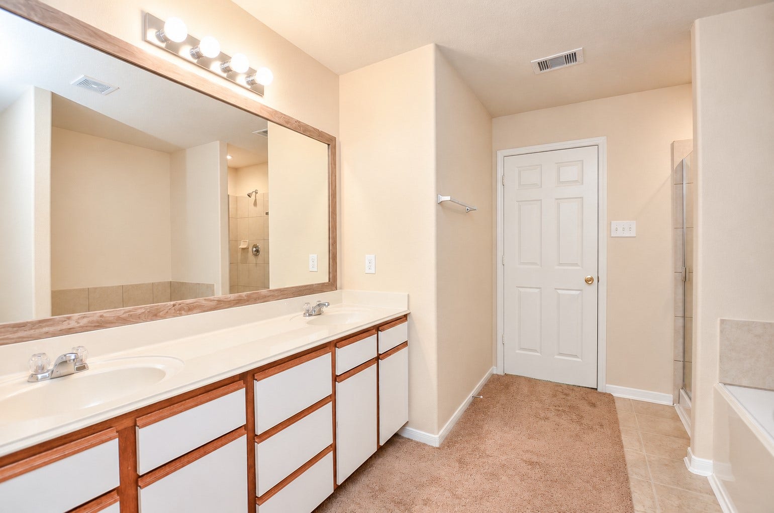 5031 Grove Square Court, Katy, TX 77449 Spacious primary bathroom with an extended dual-sink vanity, large framed mirror and separate tub and shower.