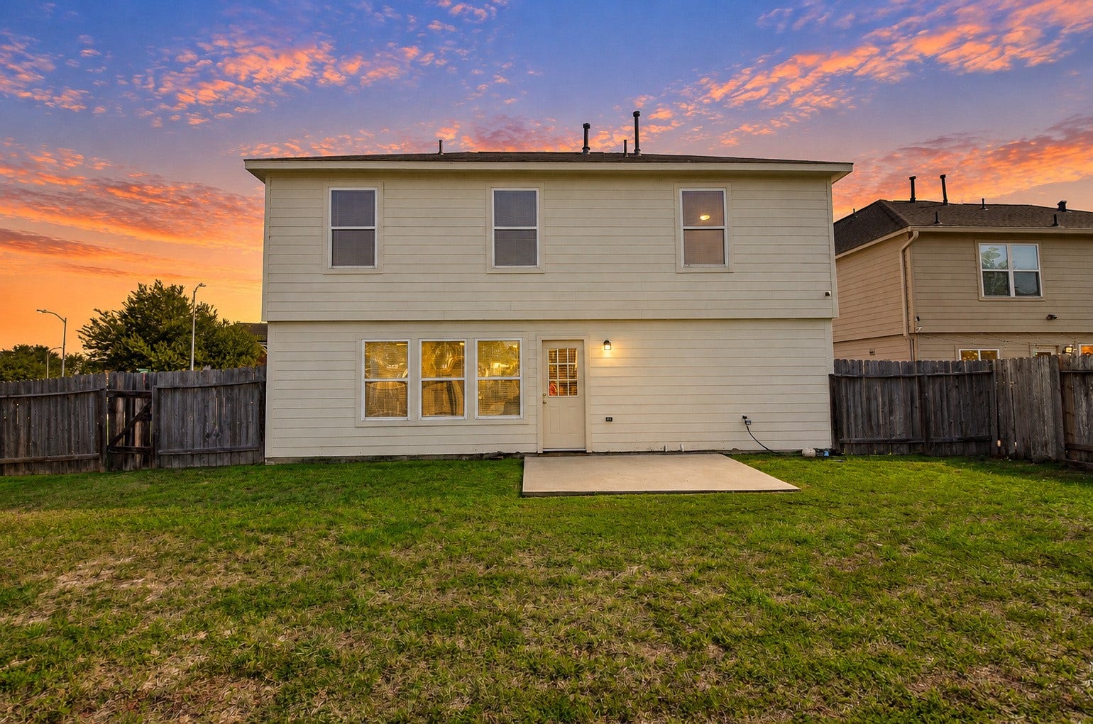 5031 Grove Square Court, Katy, TX 77449 Full rear elevation showcasing the two-story home, multiple windows, concrete patio and spacious fenced backyard.