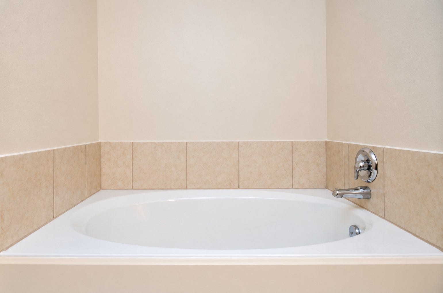 5031 Grove Square Court, Katy, TX 77449 Relaxing soaking tub in the first-floor primary bathroom, featuring a tiled surround and separate shower nearby.