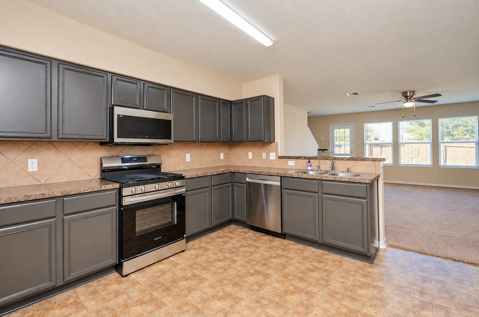 5031 Grove Square Court, Katy, TX 77449 Open kitchen layout featuring stainless steel appliances, ample storage and a breakfast bar overlooking the family room.