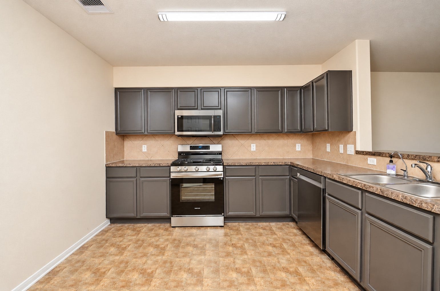 5031 Grove Square Court, Katy, TX 77449 Well-appointed kitchen with gray cabinetry, stainless steel appliances, gas range and abundant countertop space.