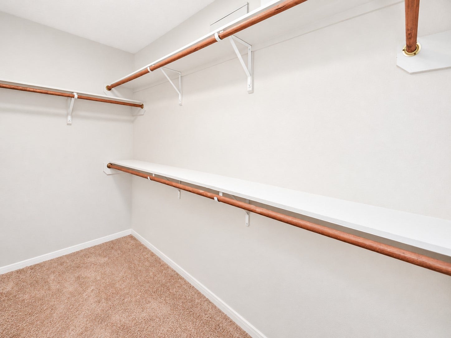 5031 Grove Square Court, Katy, TX 77449 First-floor primary walk-in closet featuring multiple hanging rods and shelving for convenient storage and organization.