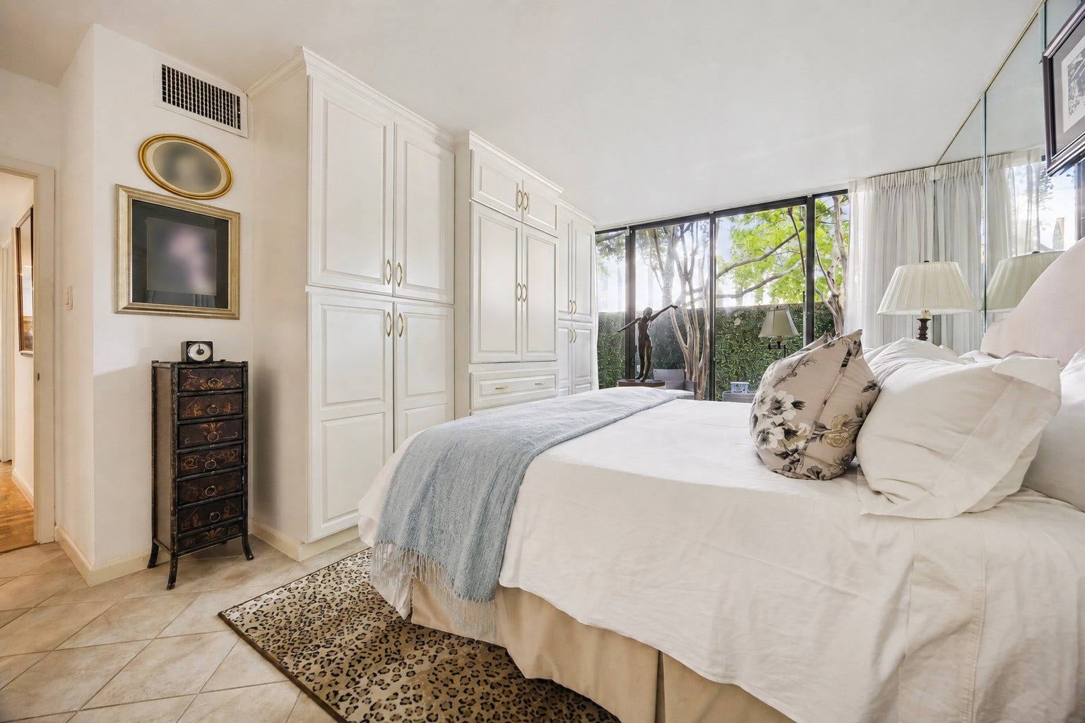 Another angle of the primary bedroom with the luxury of space. Elegant integrated custom built-in cabinetry and storage replacing bulking furniture for a clean cohesive look.