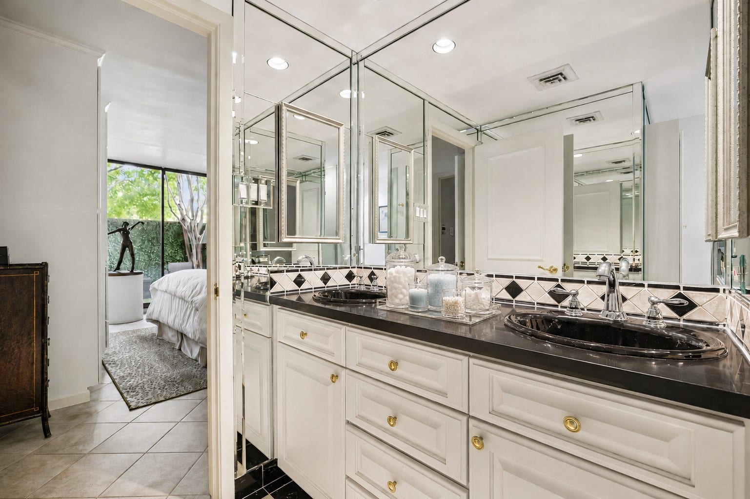 Alternate on-suite primary bathroom view featuring custom, comfort height, built-in vanities with gorgeous granite slab counter, accented with decorative tile backsplash