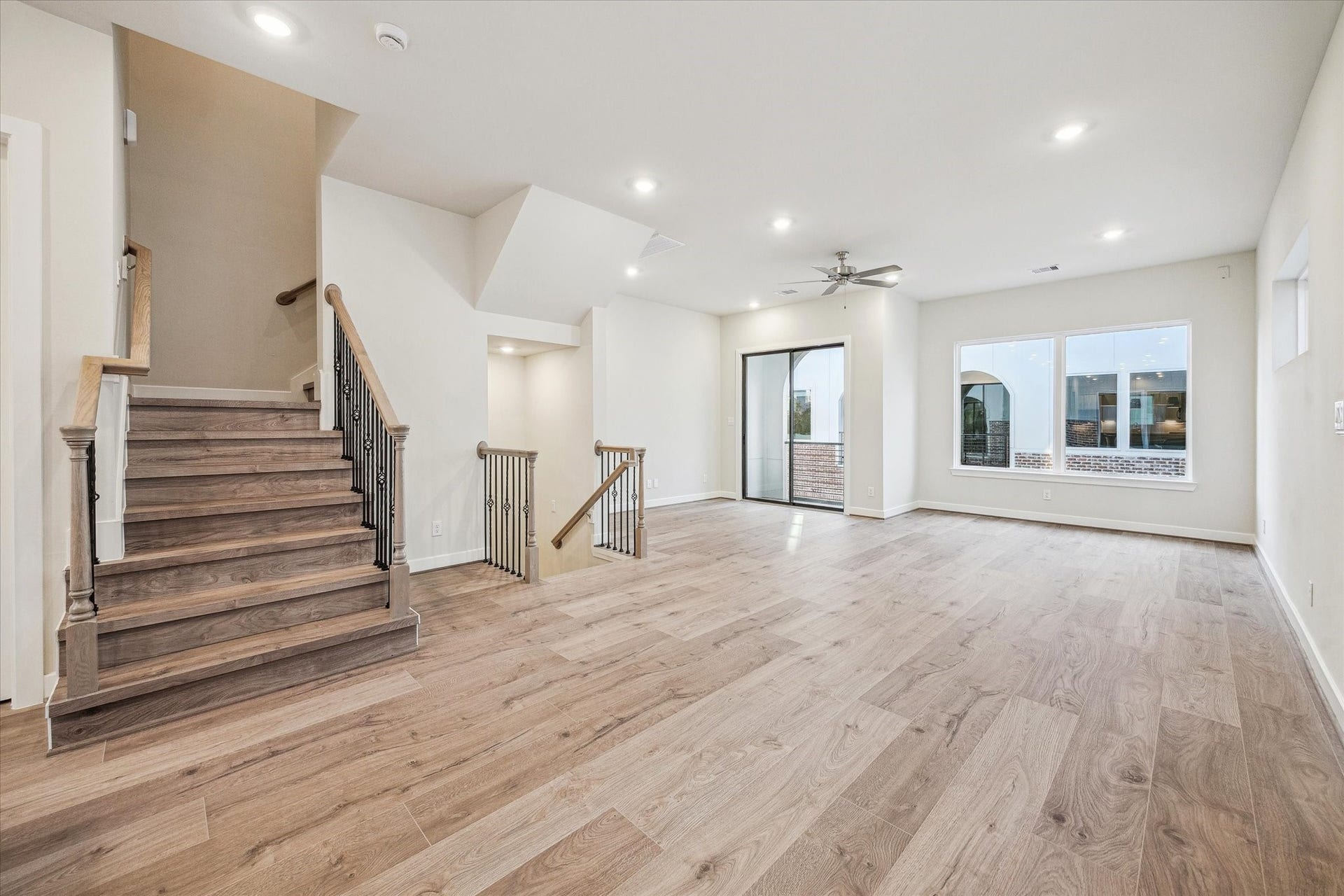 Spacious second-floor living area featuring a private balcony just off the main living space.