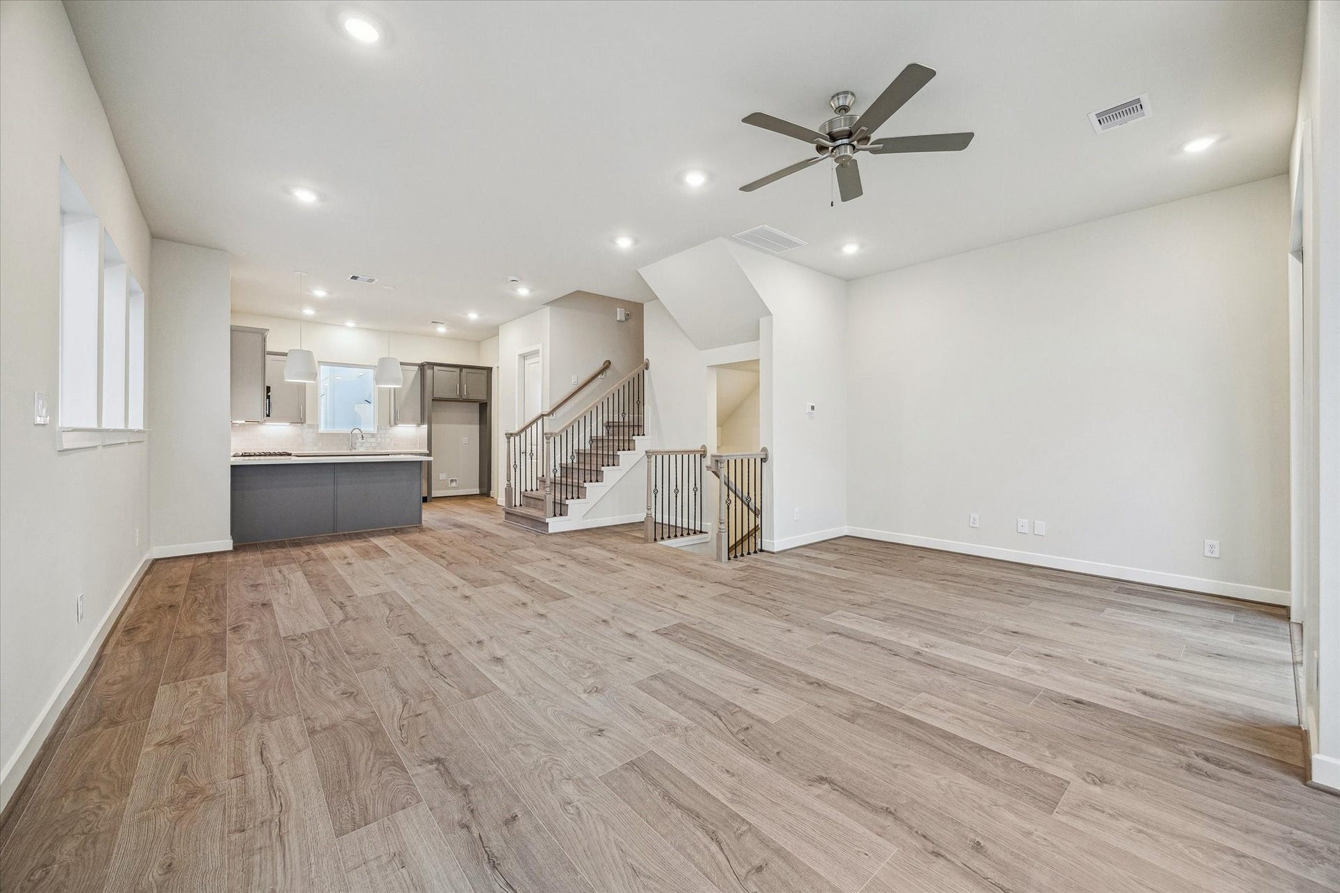 Spacious open-concept second-floor living area with room for dining and entertaining, featuring high ceilings, balcony access, and an easy flow into the kitchen.