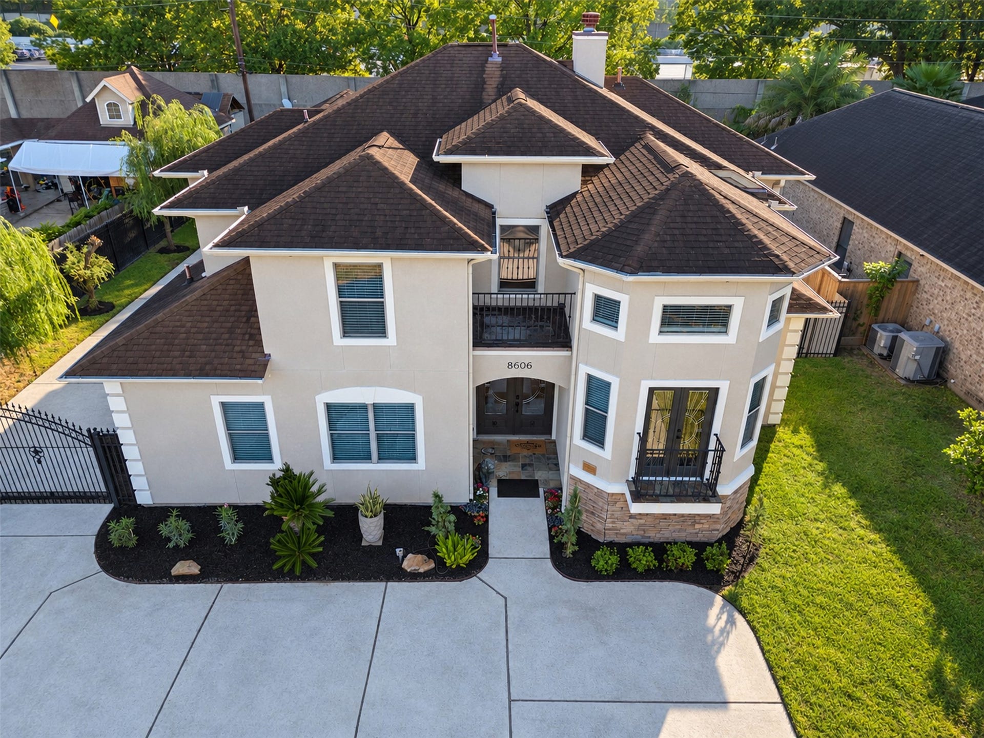 8606 Argentina Street, Houston, TX 77040 Front Exterior: Distinctive two-story architecture with an elegant stucco faade, stone accents, and two balconies that create striking curb appeal.
