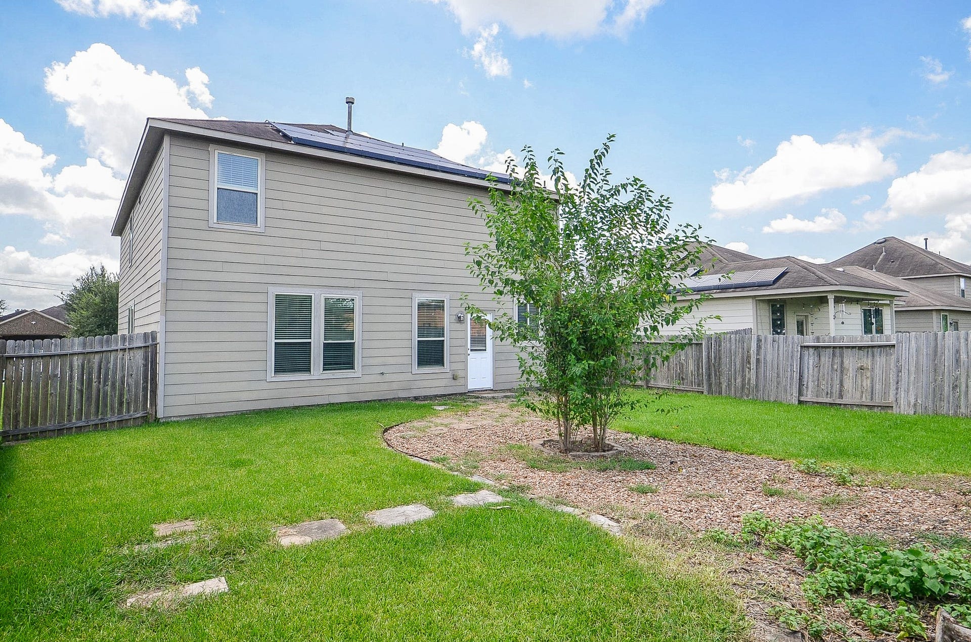 2539 Bedrock Lane, Missouri City, TX 77489 Spacious backyard with a charming path and lush greenery, perfect for outdoor activities and relaxation.