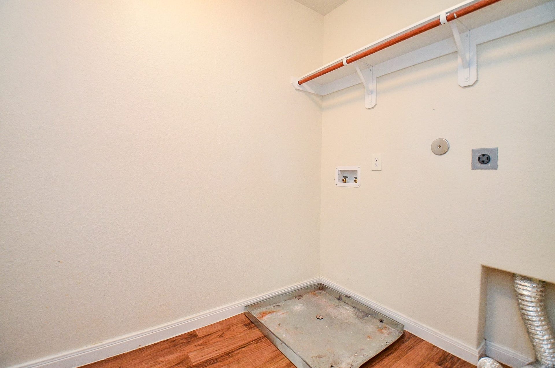 2539 Bedrock Lane, Missouri City, TX 77489 Spacious laundry room with washer/dryer hookups, bright walls, and a convenient shelf for storage.