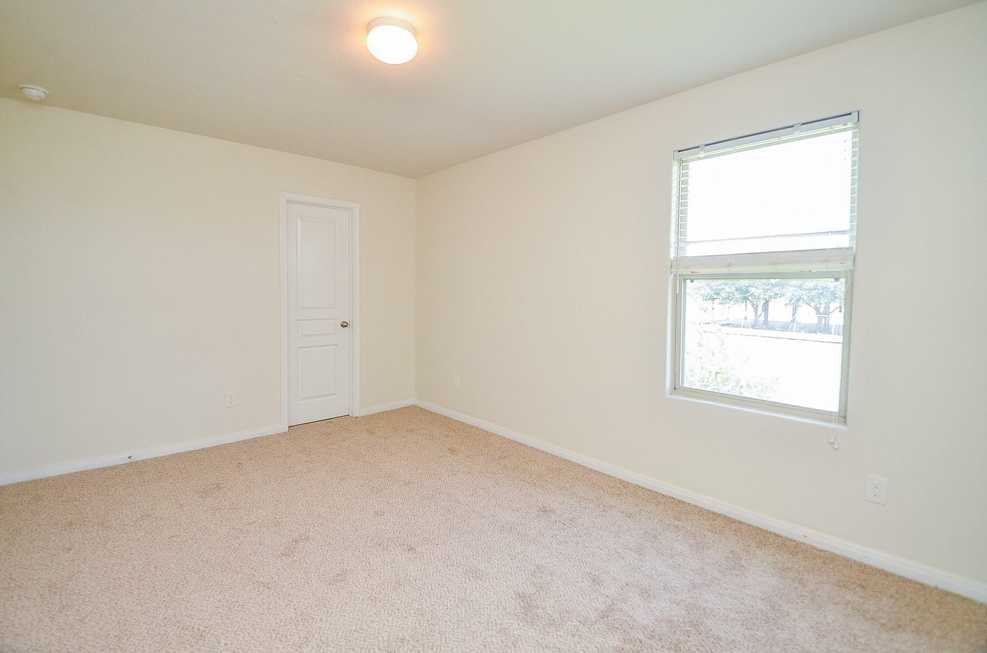 2539 Bedrock Lane, Missouri City, TX 77489 Bright and airy bedroom with soft carpet flooring, neutral walls, and a large window allowing natural light to fill the space.